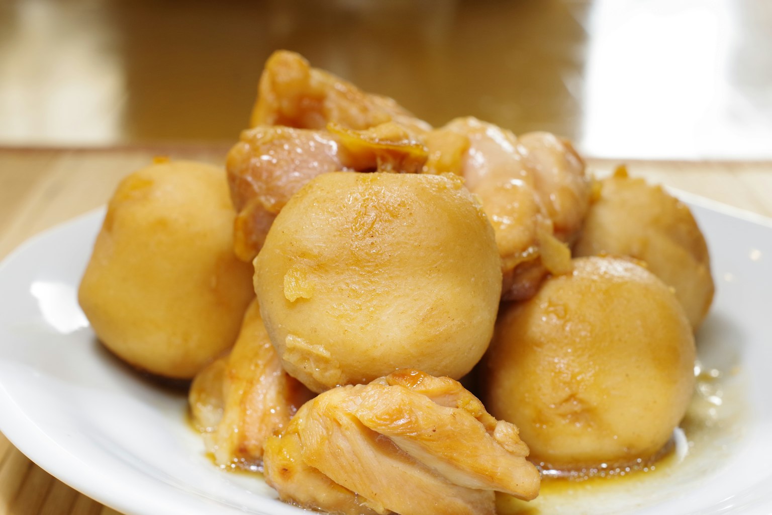 Un piatto con pollo e patate rotonde servito su un piatto bianco