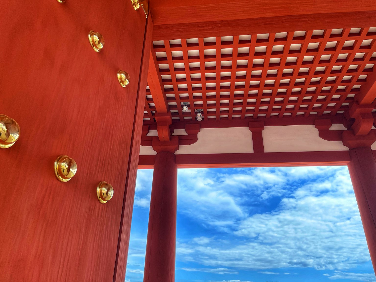 Vista interna di un edificio con colonne rosse e soffitto a griglia
