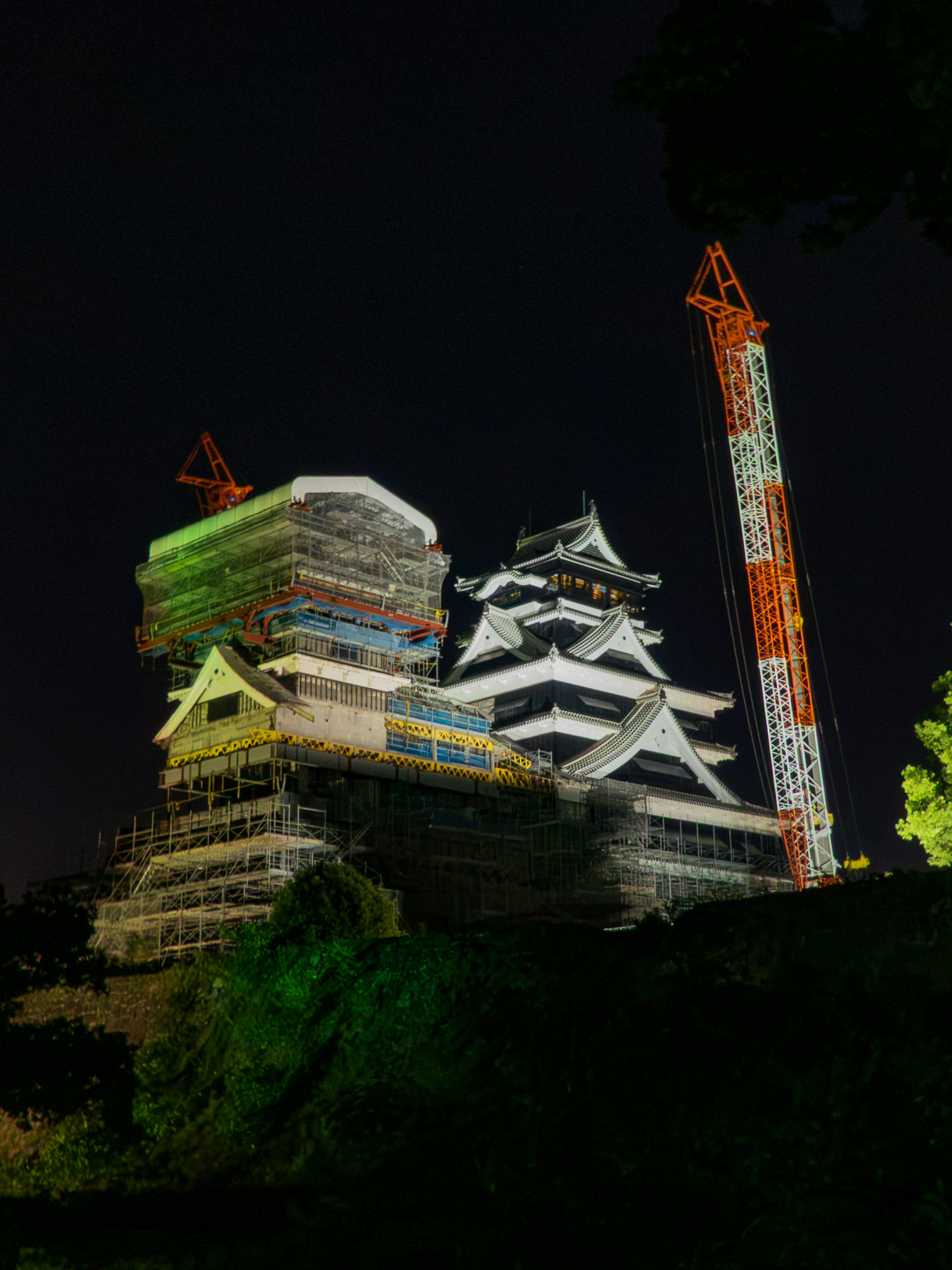 le château de Kumamoto illuminé la nuit, donjon et travaux de restauration