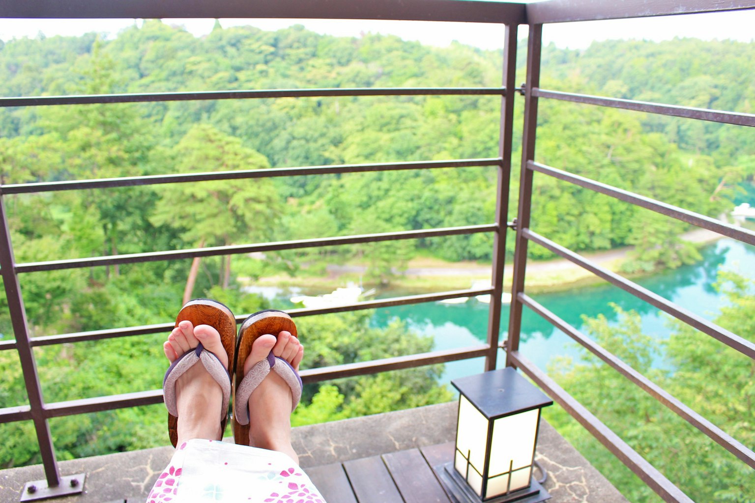 Relaxing feet on a balcony overlooking lush green scenery