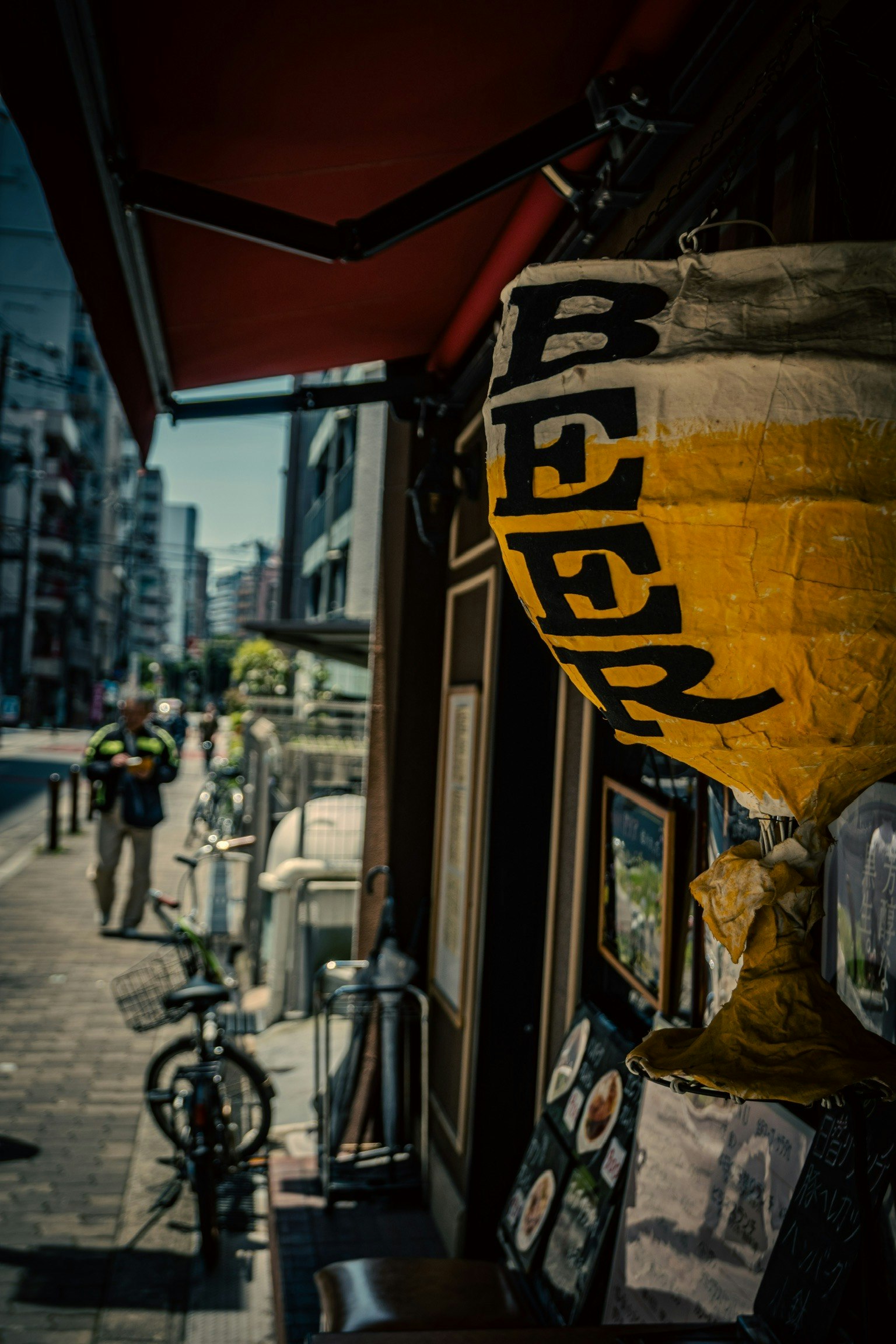 ビールの提灯が掛かる居酒屋の外観と通りの風景