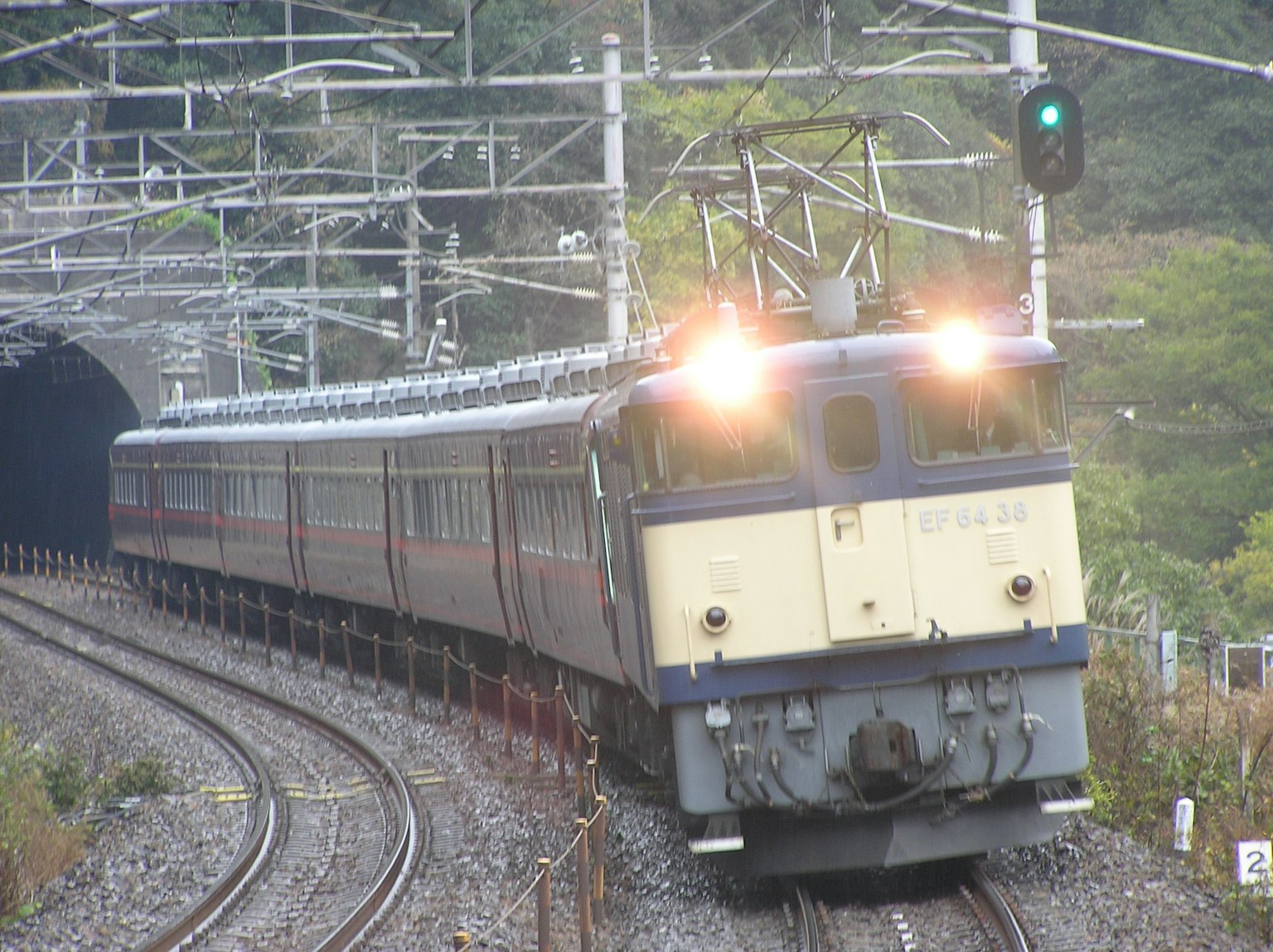 Un tren acercándose a un túnel con su vista lateral visible
