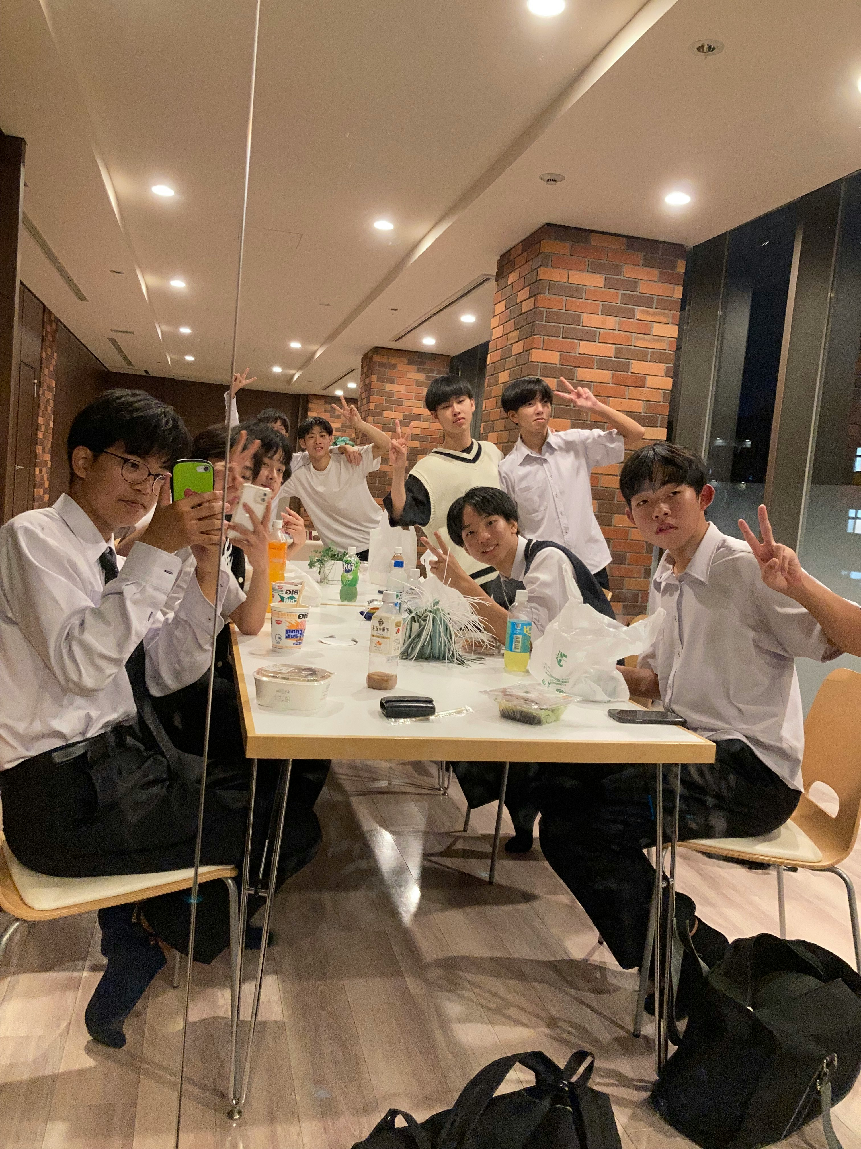 穿白襯衫的學生在餐桌前合影擺姿勢