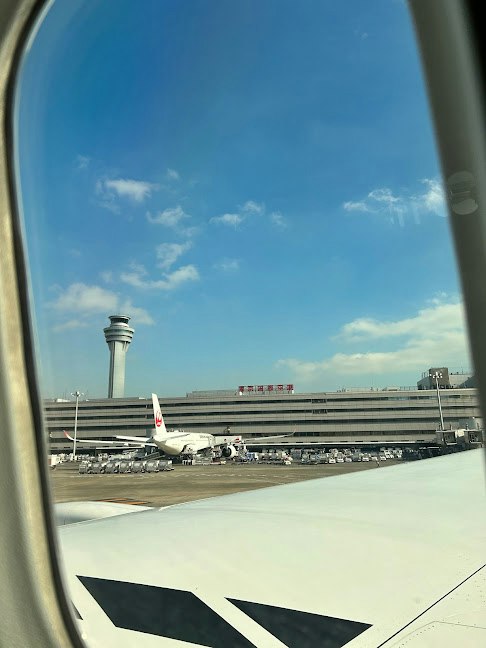airport runway and control tower seen through an airplane window
