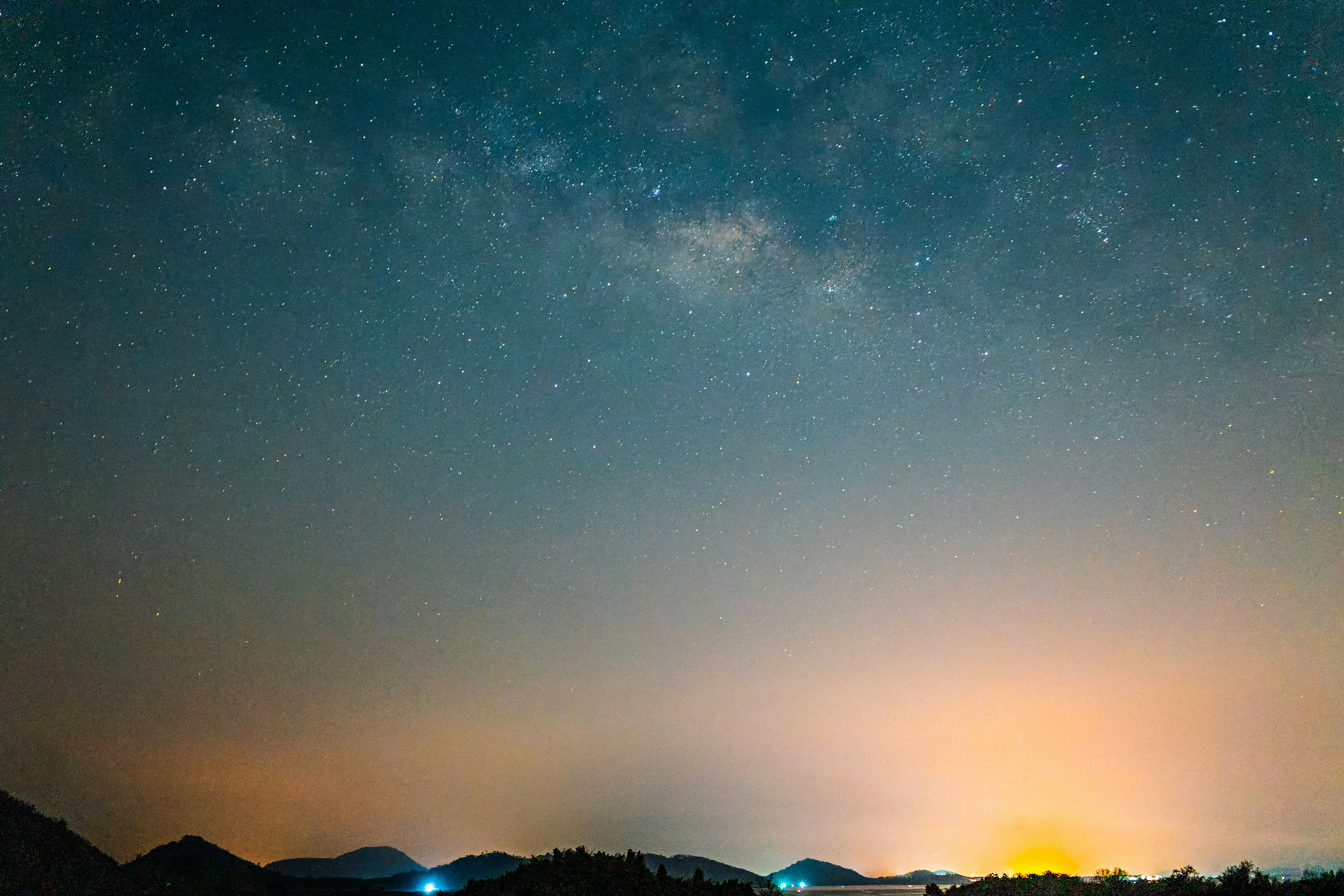 天の川が広がる夜空と山並みのシルエット