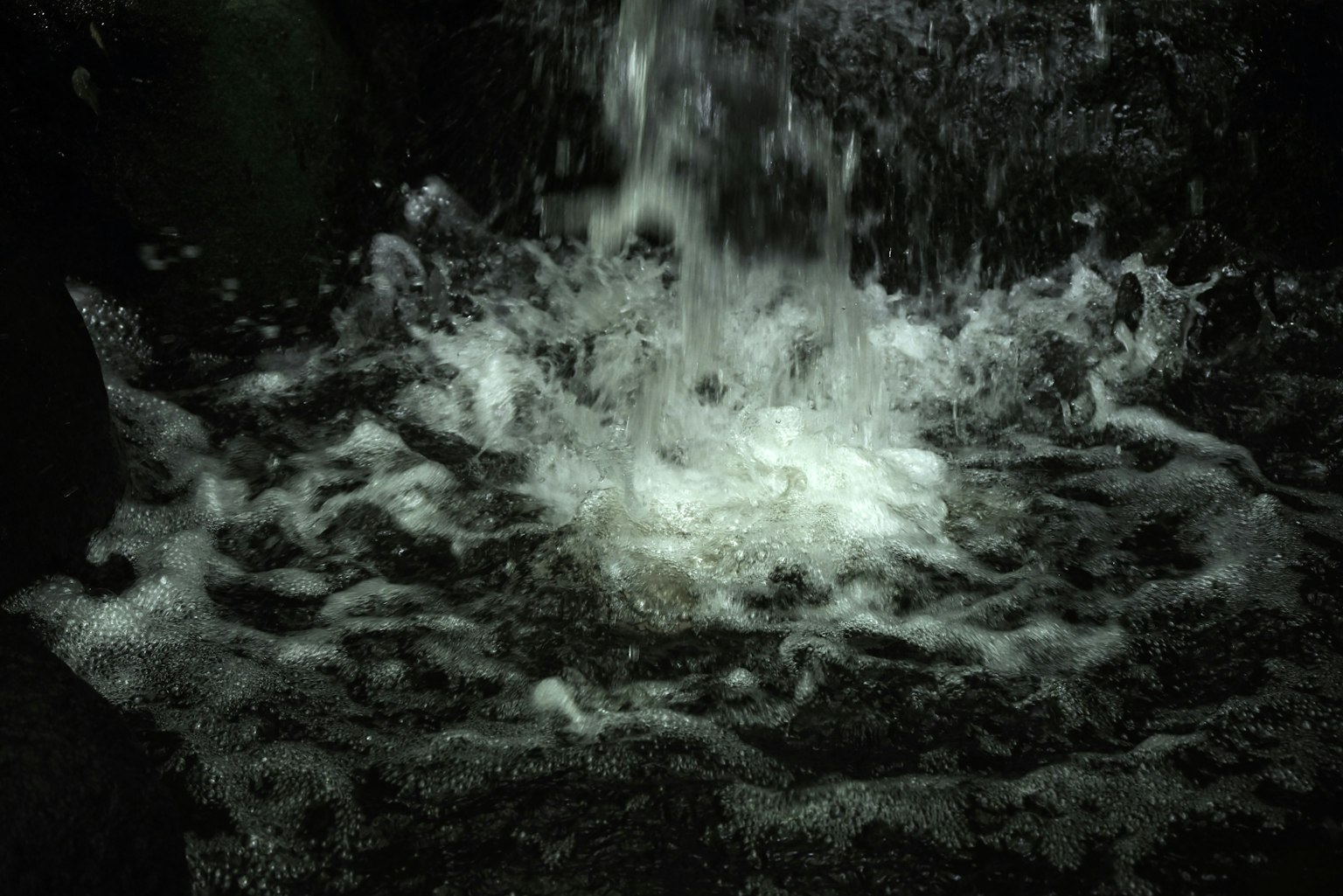 Wasser, das über Felsen fließt und Spritzer und Blasen erzeugt