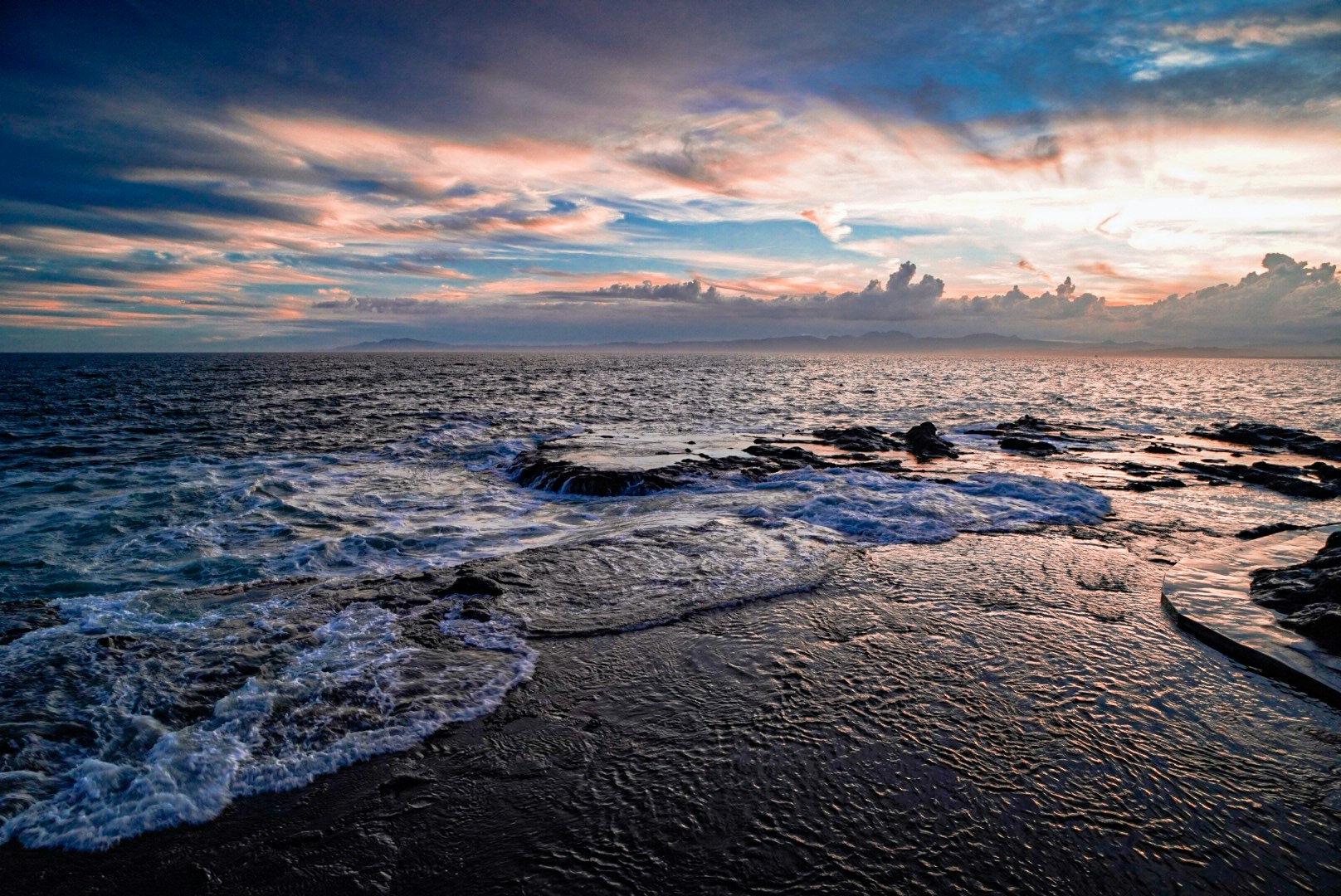 côte rocheuse avec des vagues au coucher du soleil