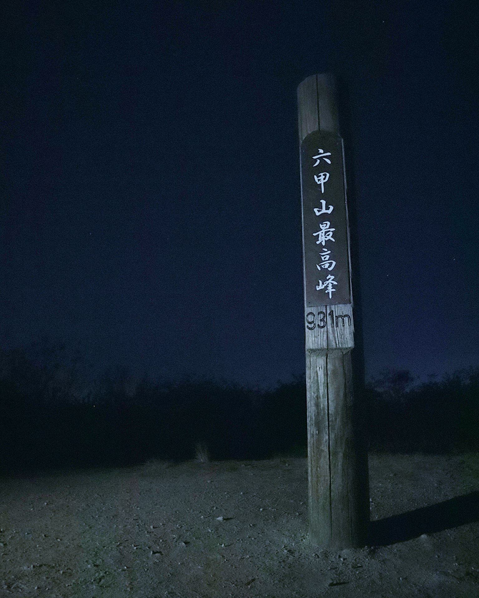 Papan kayu yang diterangi di malam hari dengan karakter Jepang