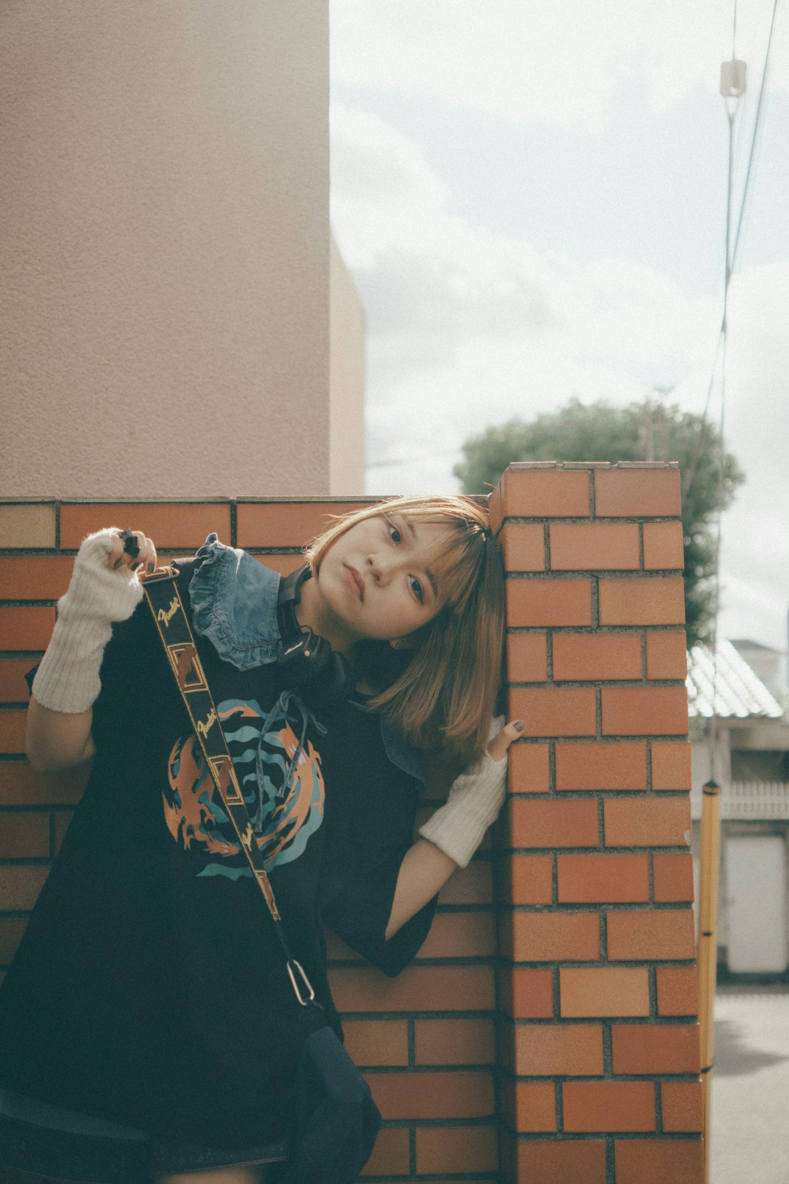 Retrato de moda de una mujer apoyada en una pared de ladrillos