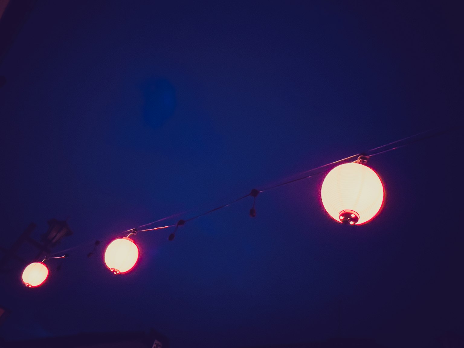 Red hanging lamps against a blue background