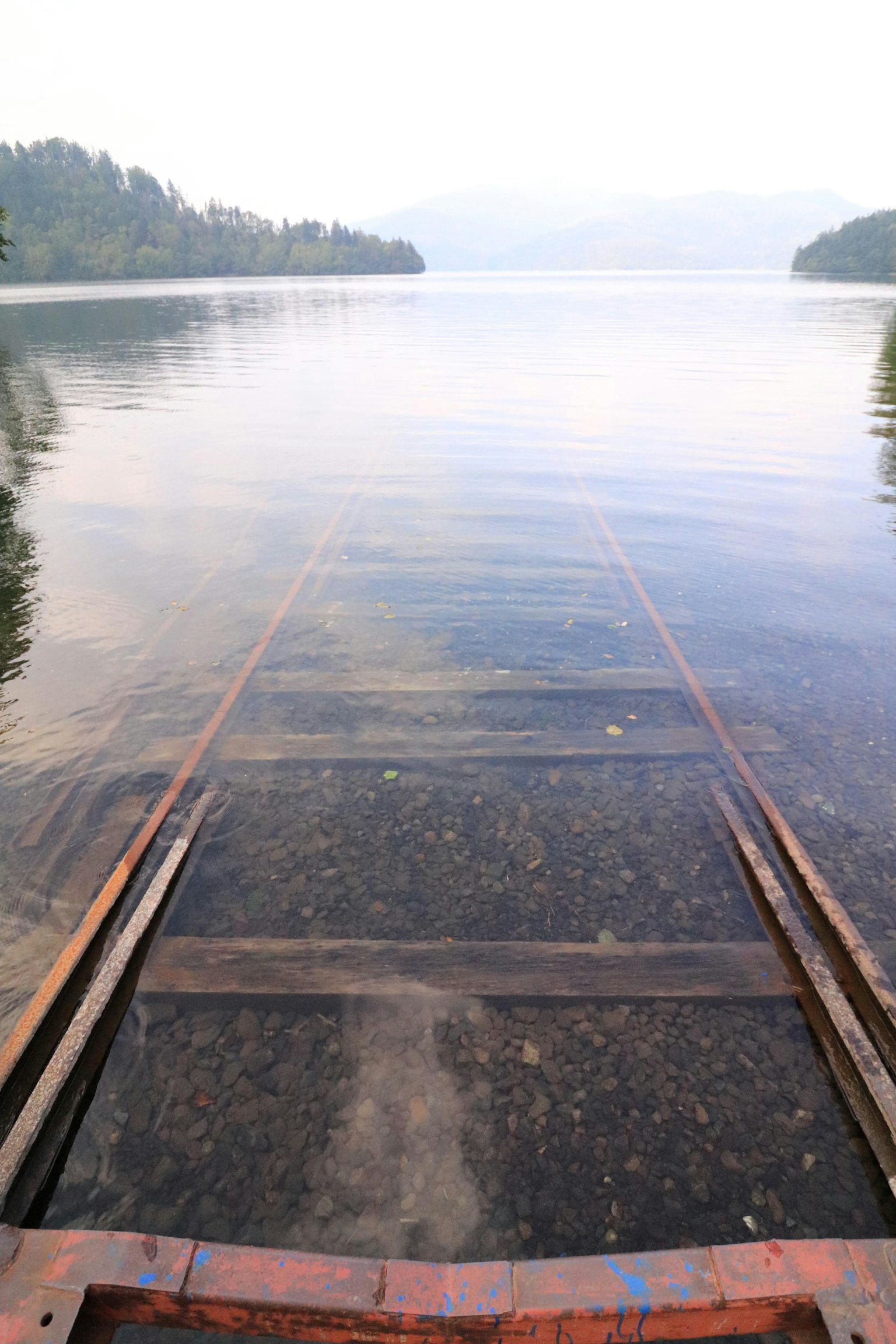 View of an old dock leading into a calm lake