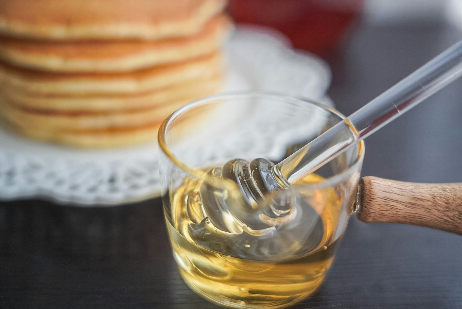 honey-like golden liquid being poured with a wooden-handled spoon