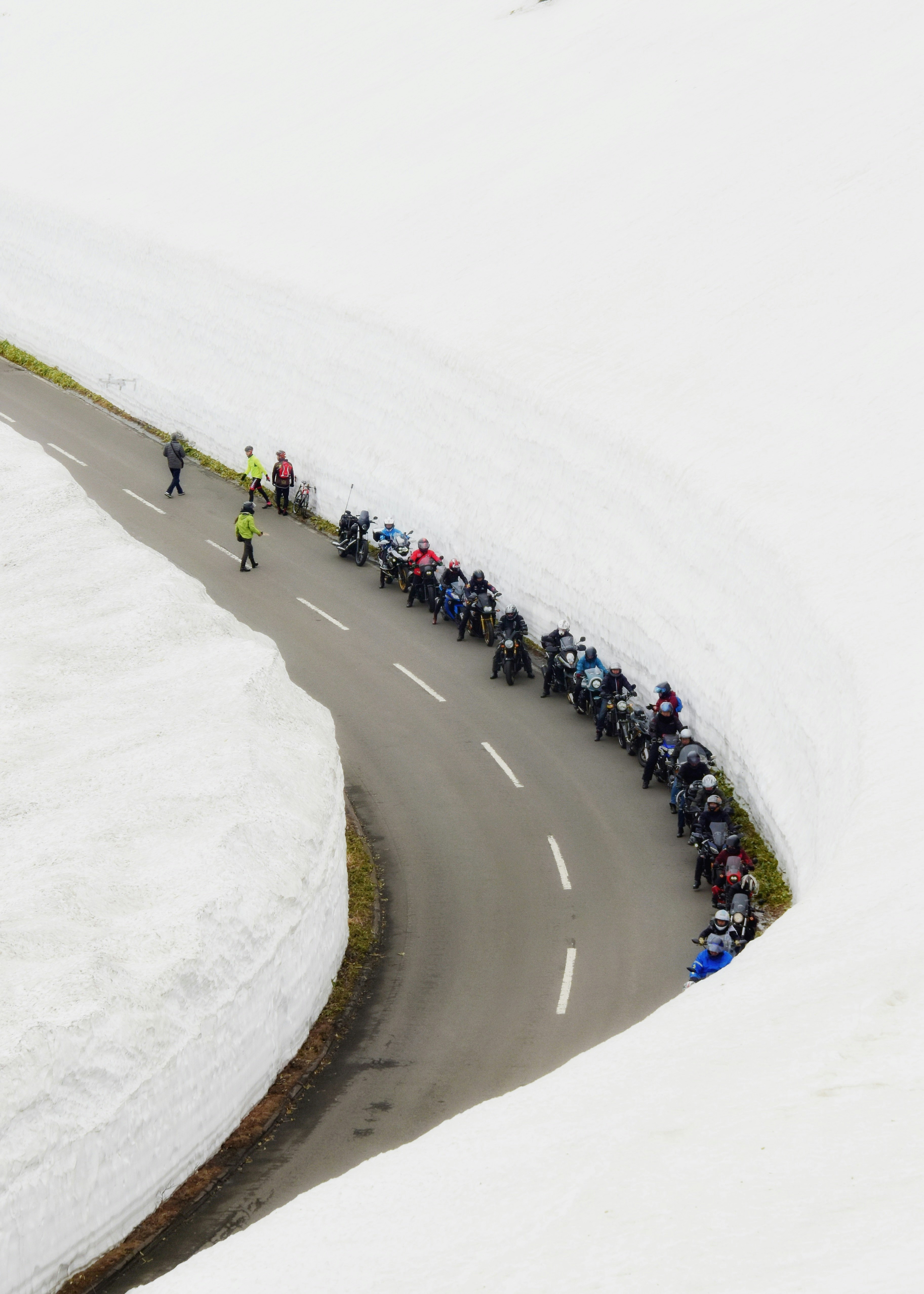 雪の回廊を走るツーリングバイクの列（渋峠）