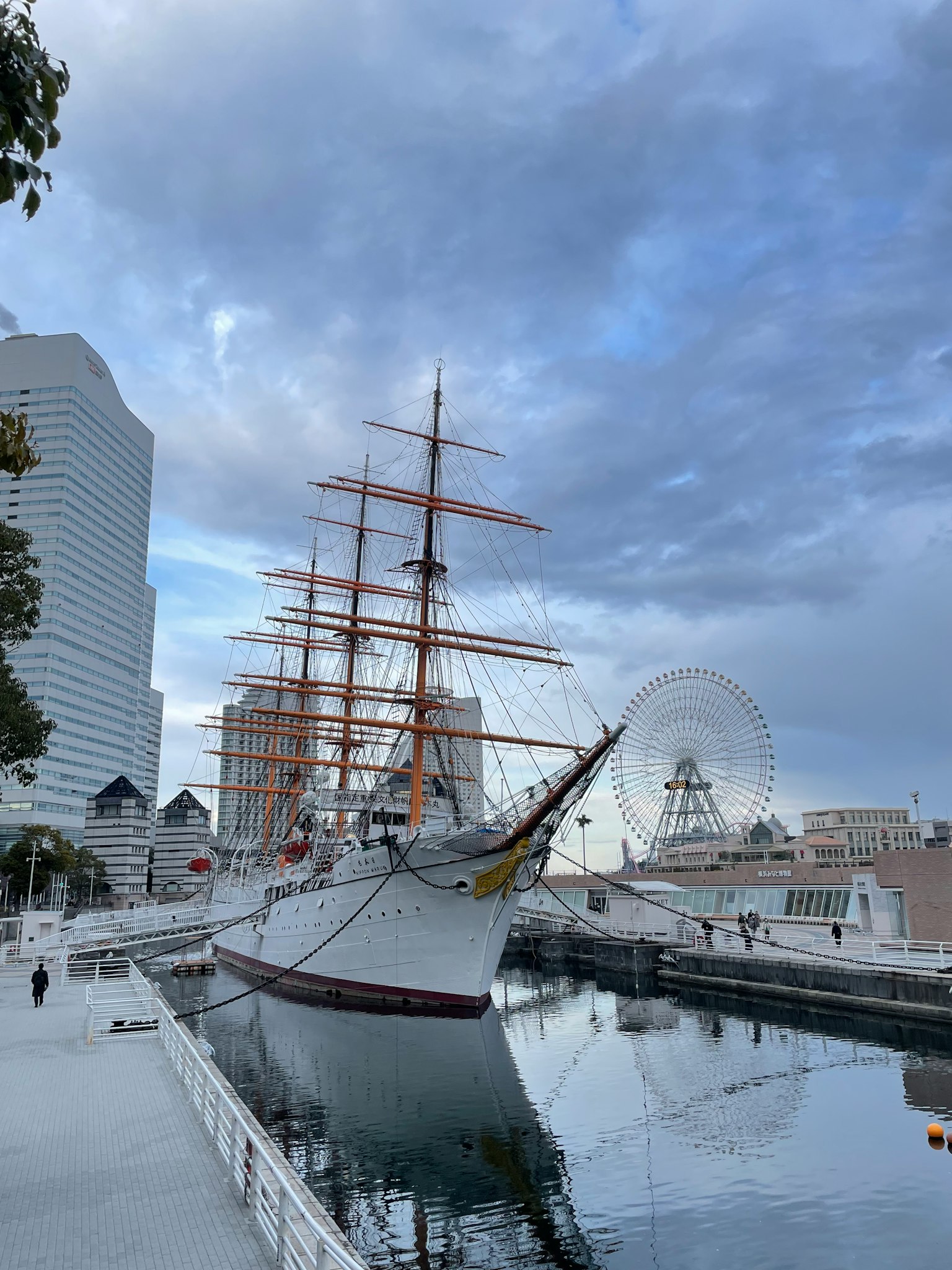 Una nave a vela ormeggiata nel porto di Yokohama con grattacieli sullo sfondo