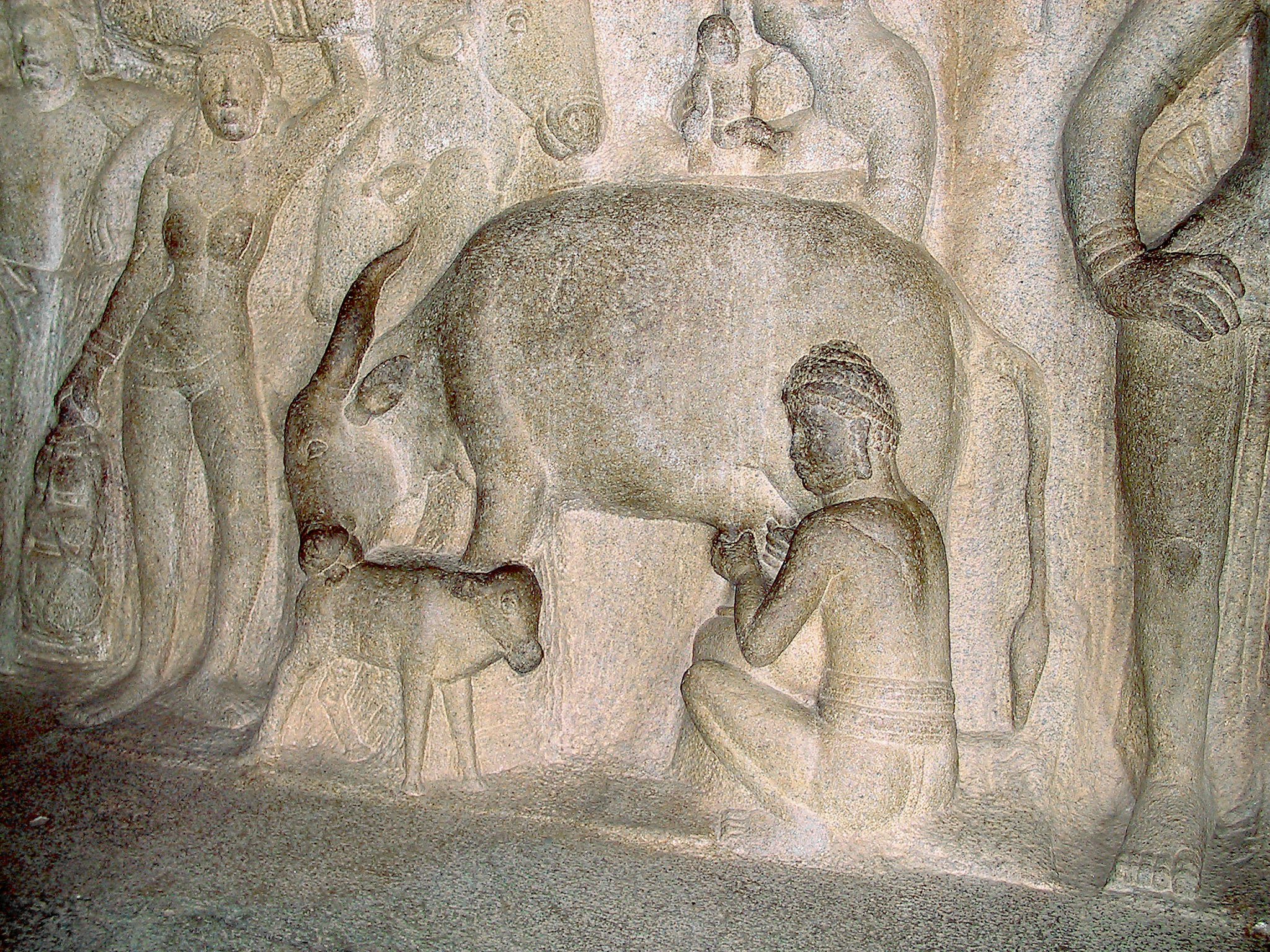 bas-relief en pierre représentant des personnages et un animal sur un mur