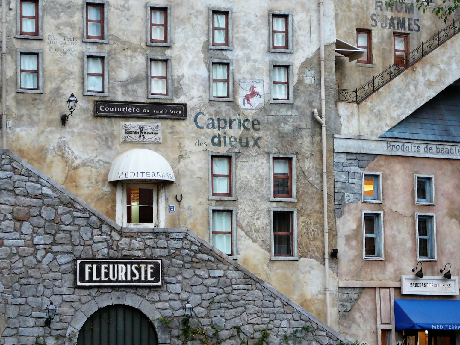 Parete di un edificio in pietra con insegne francesi e design di finestre vintage