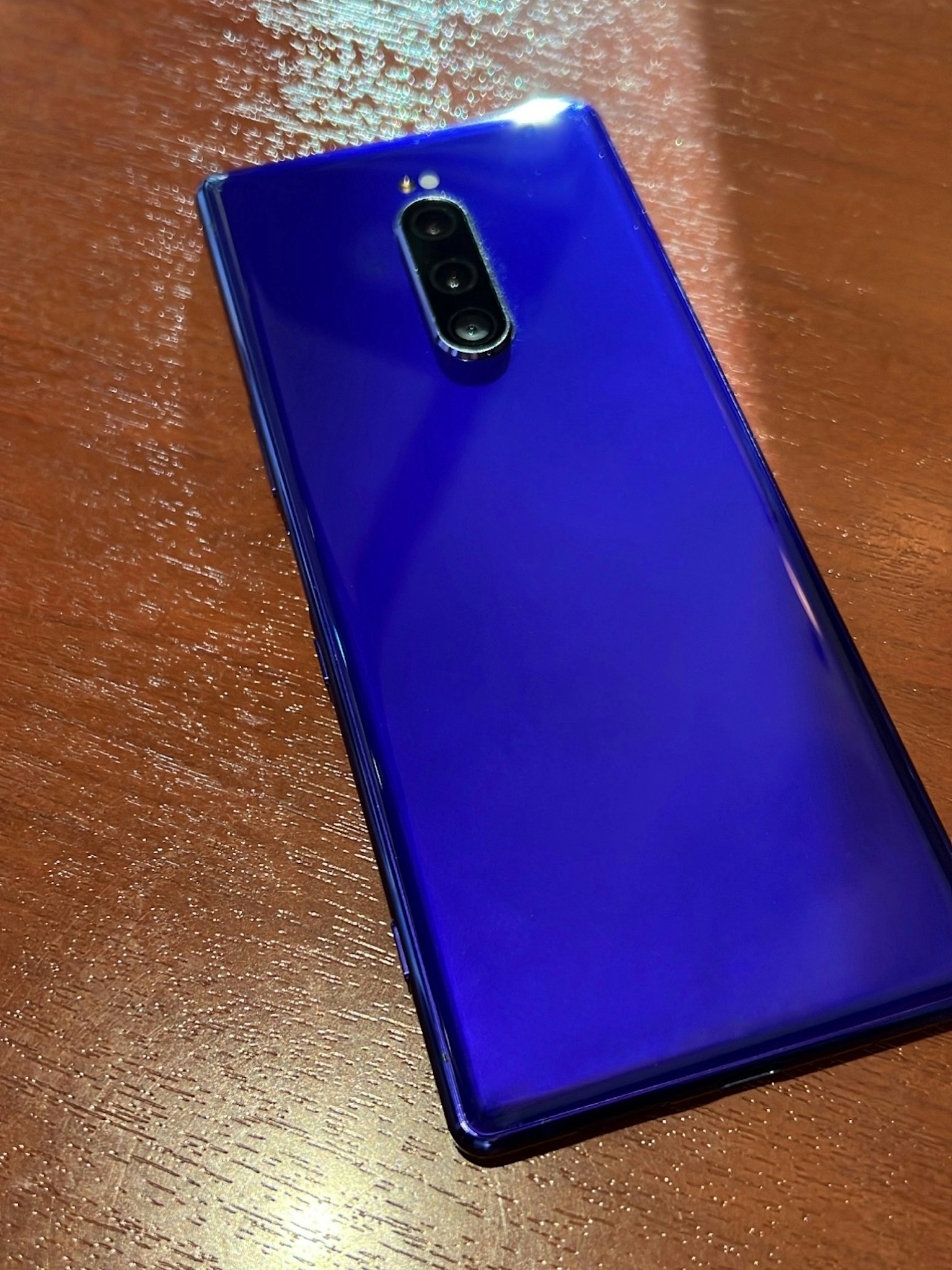 Ein lila Smartphone auf einem Holztisch
