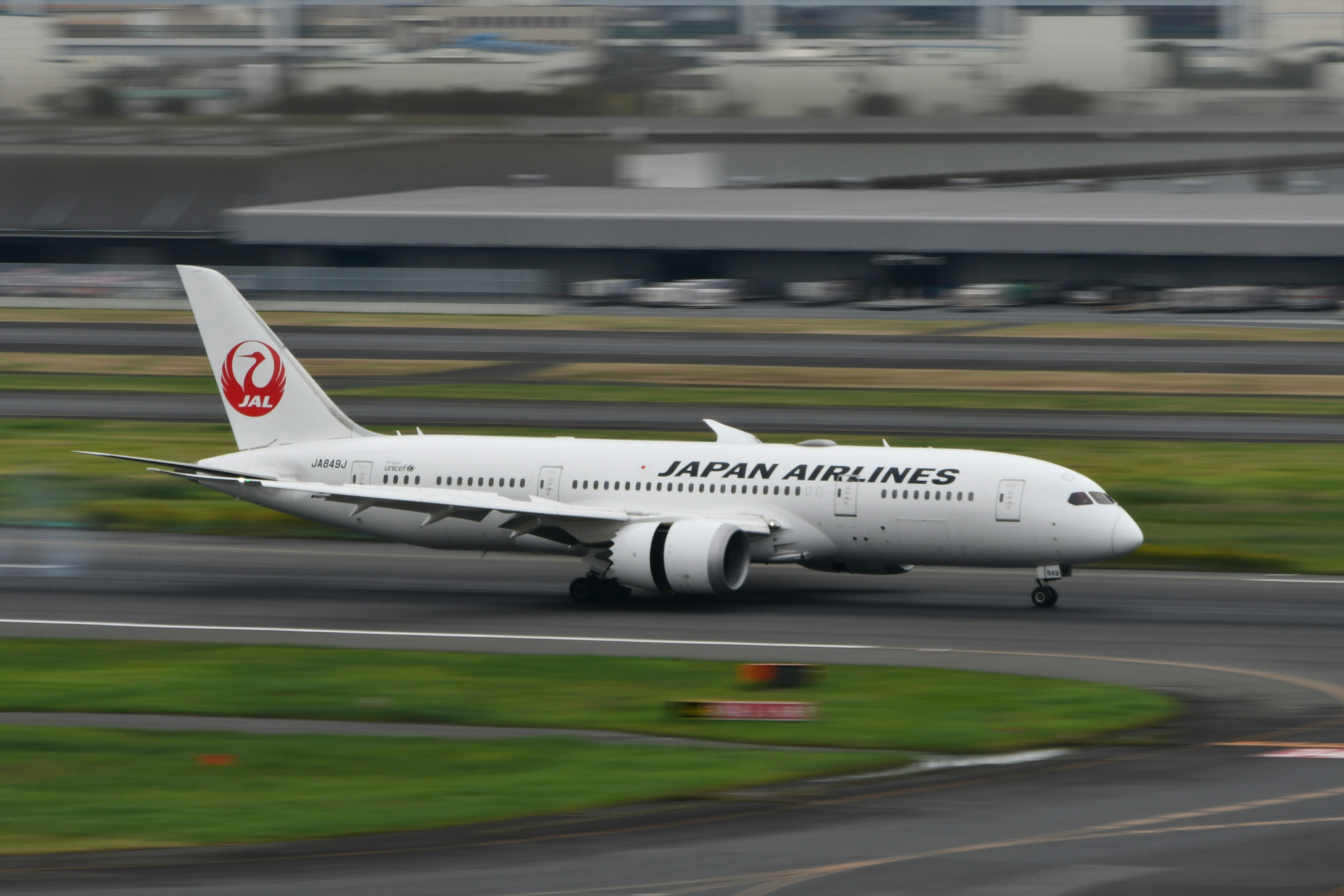 vista lateral de un avión de Japan Airlines en la pista