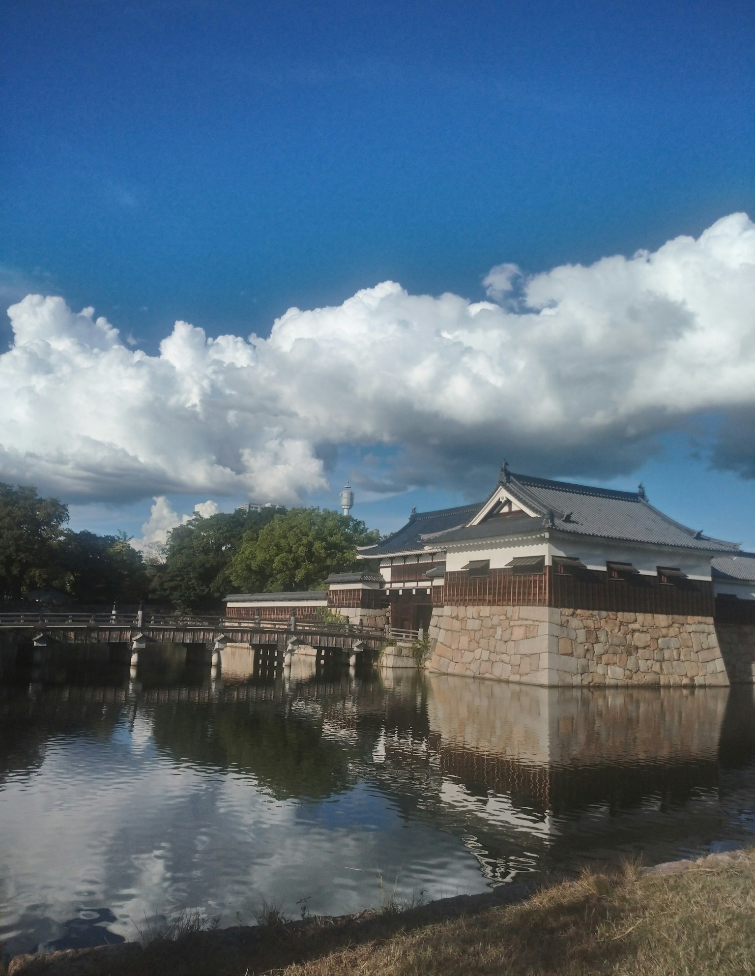 歷史城堡在水中倒影，藍天和雲朵