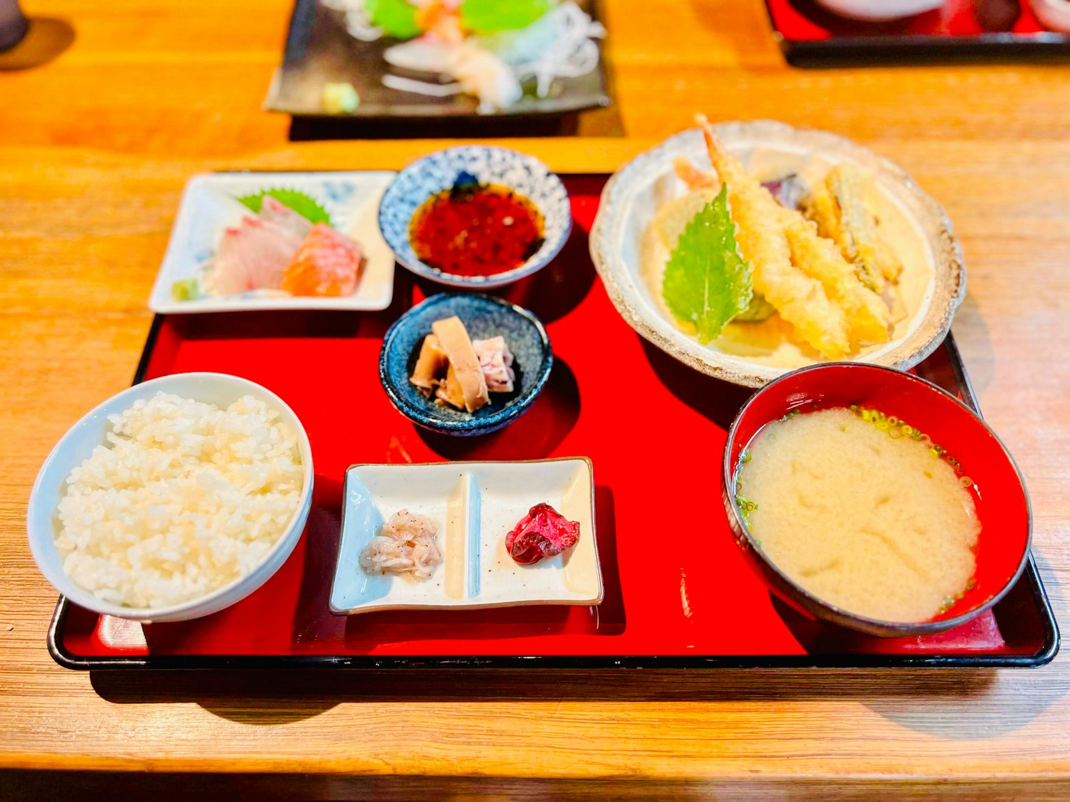 Tempura, sashimi, súp miso và cơm trắng trên khay đỏ