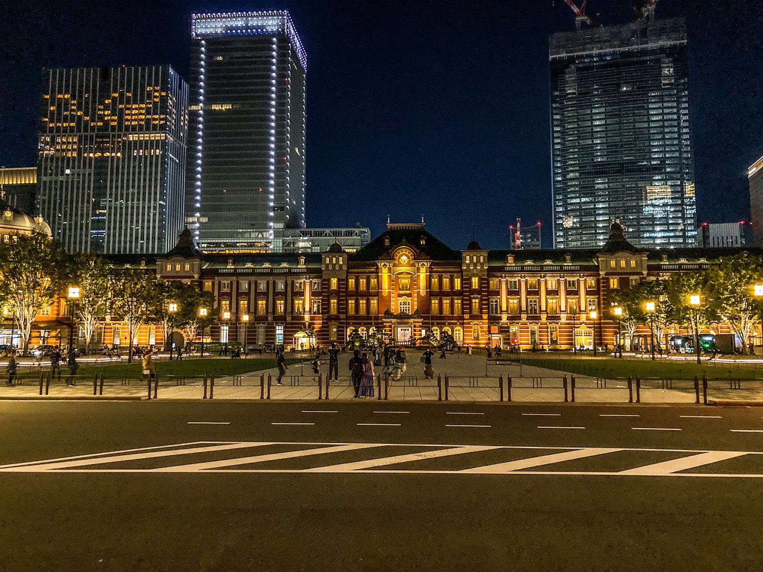 Gare de Tokyo illuminée la nuit avec des gratte-ciel environnants