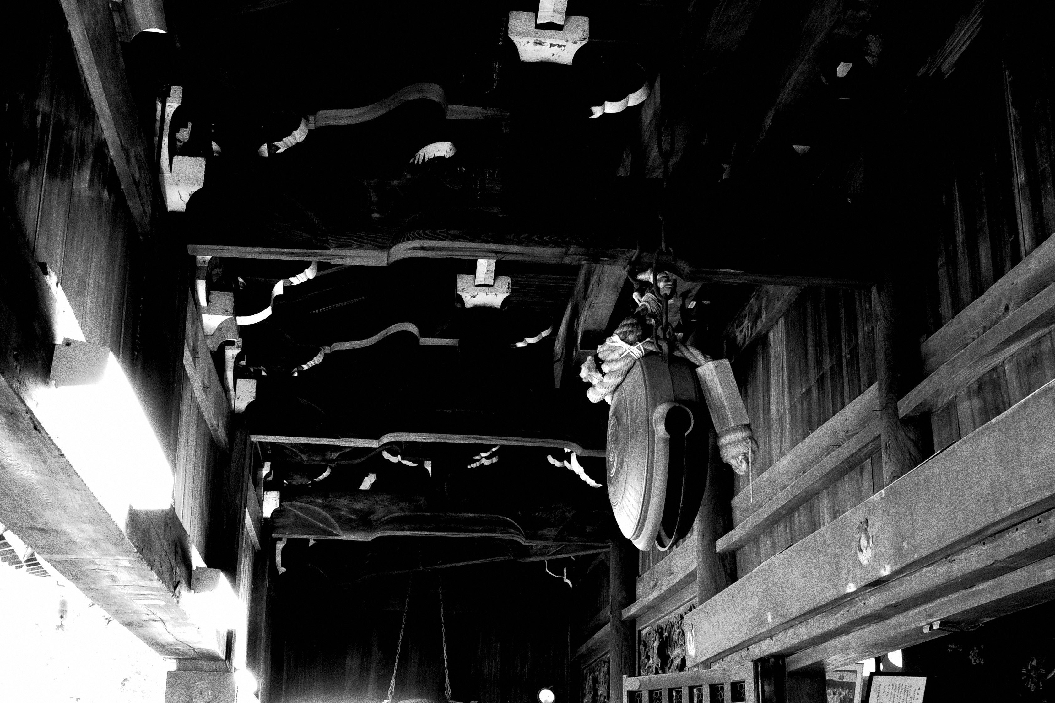 passage sombre dans une ruelle avec câblage au plafond et poutres anciennes