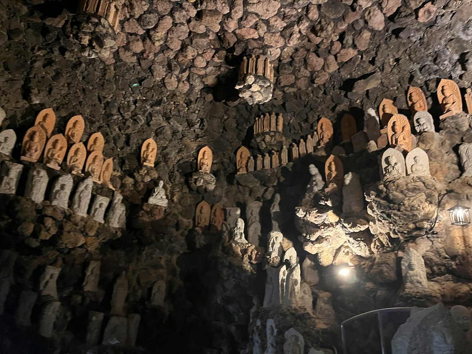 Ruang gua mistis yang dipenuhi dengan banyak patung Buddha dan ukiran batu