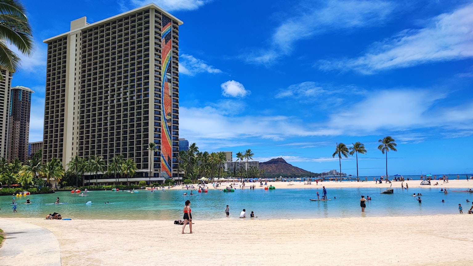 夏威夷海滩场景清澈的蓝天和背景中的高层建筑