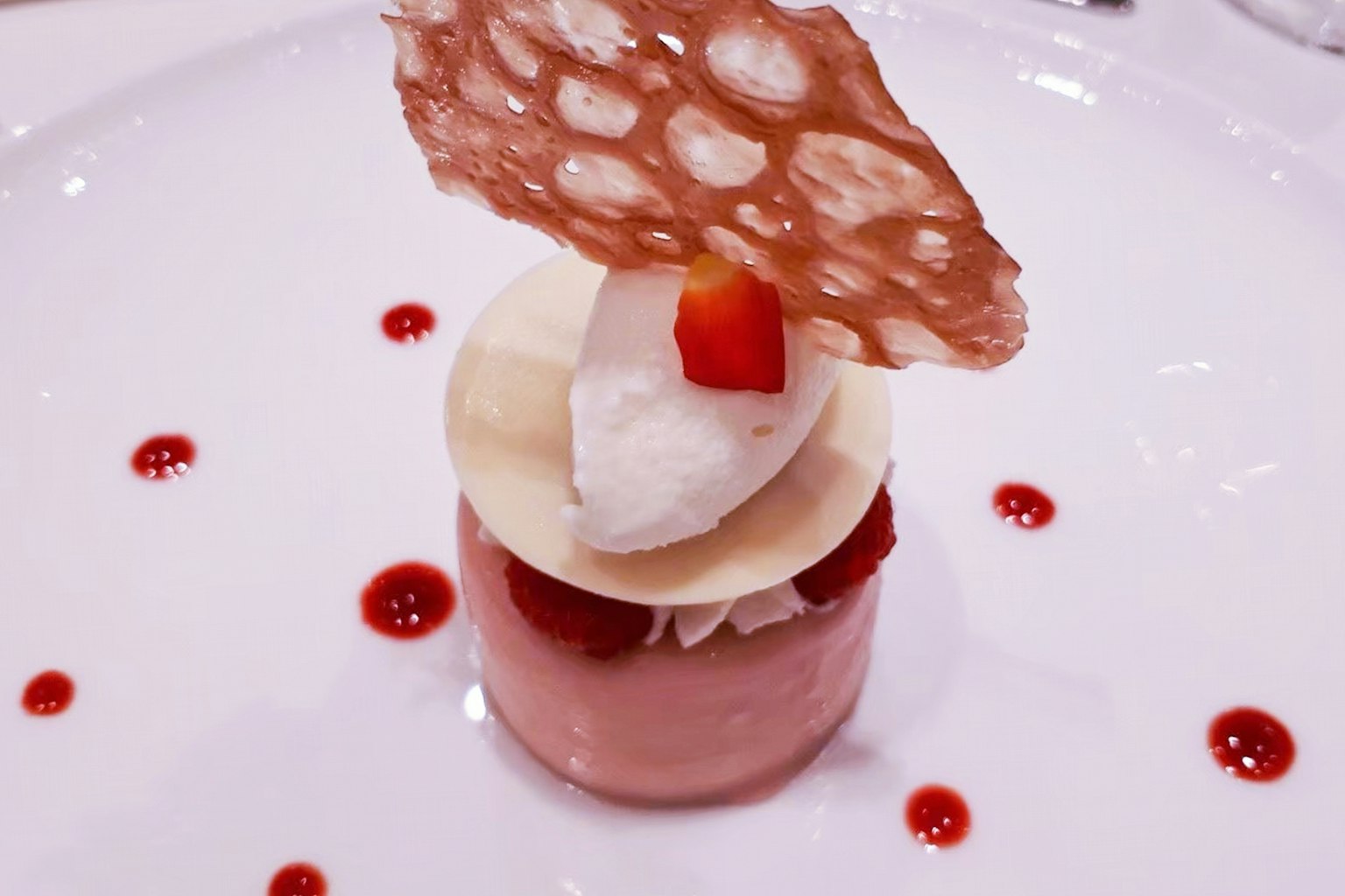 Elegantes Dessert mit Schichten aus Obst und Sahne, gekrönt von einem zarten Keks