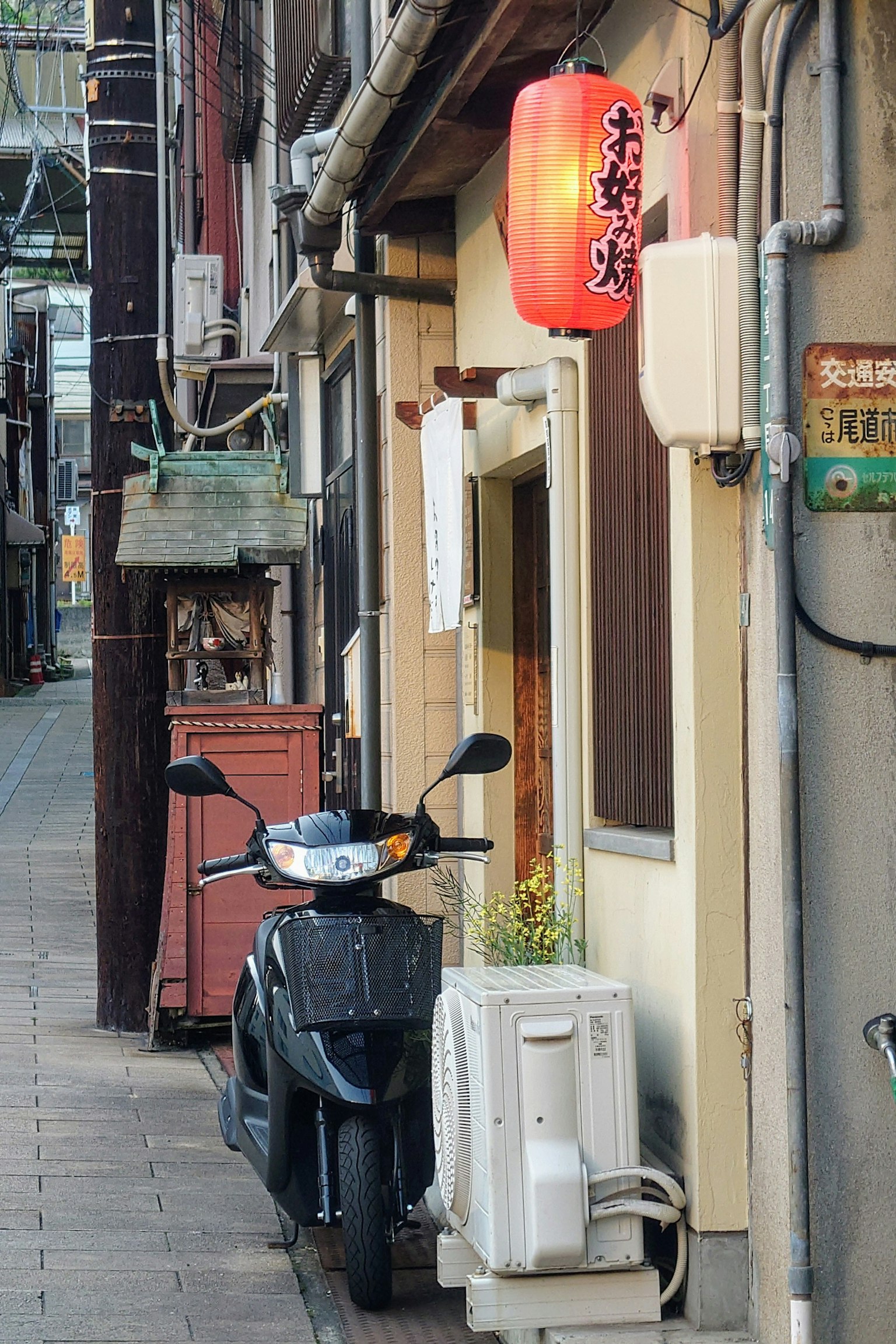 狹窄小巷中的居酒屋外觀和一輛摩托車