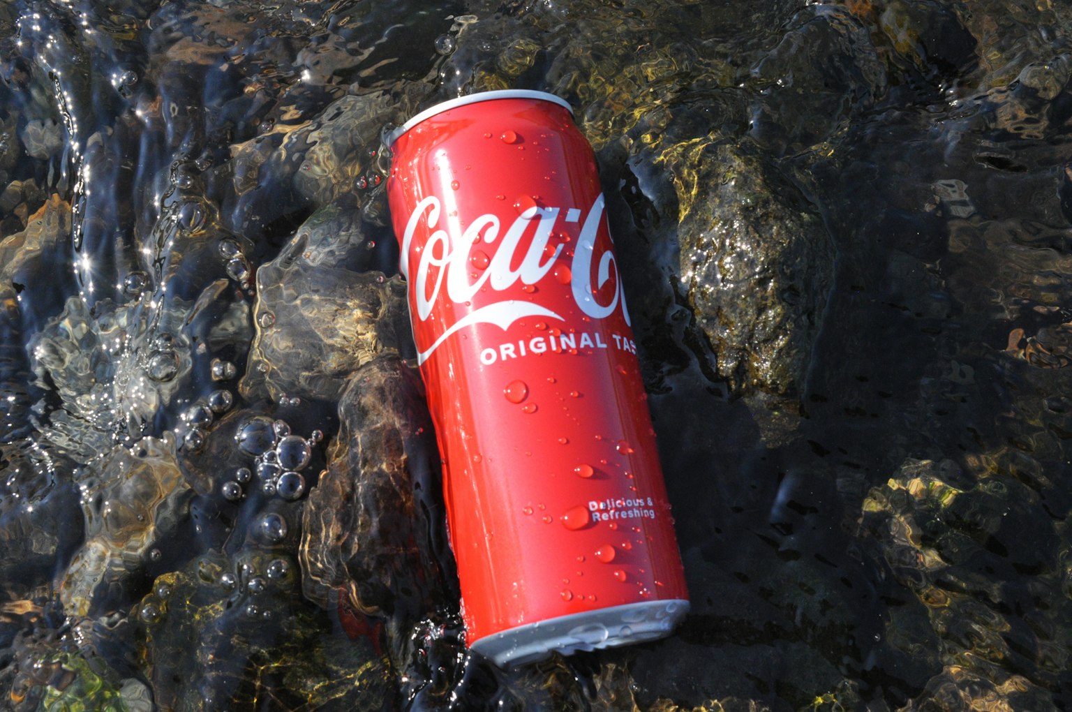 Một lon Coca-Cola lớn nằm bên cạnh nước