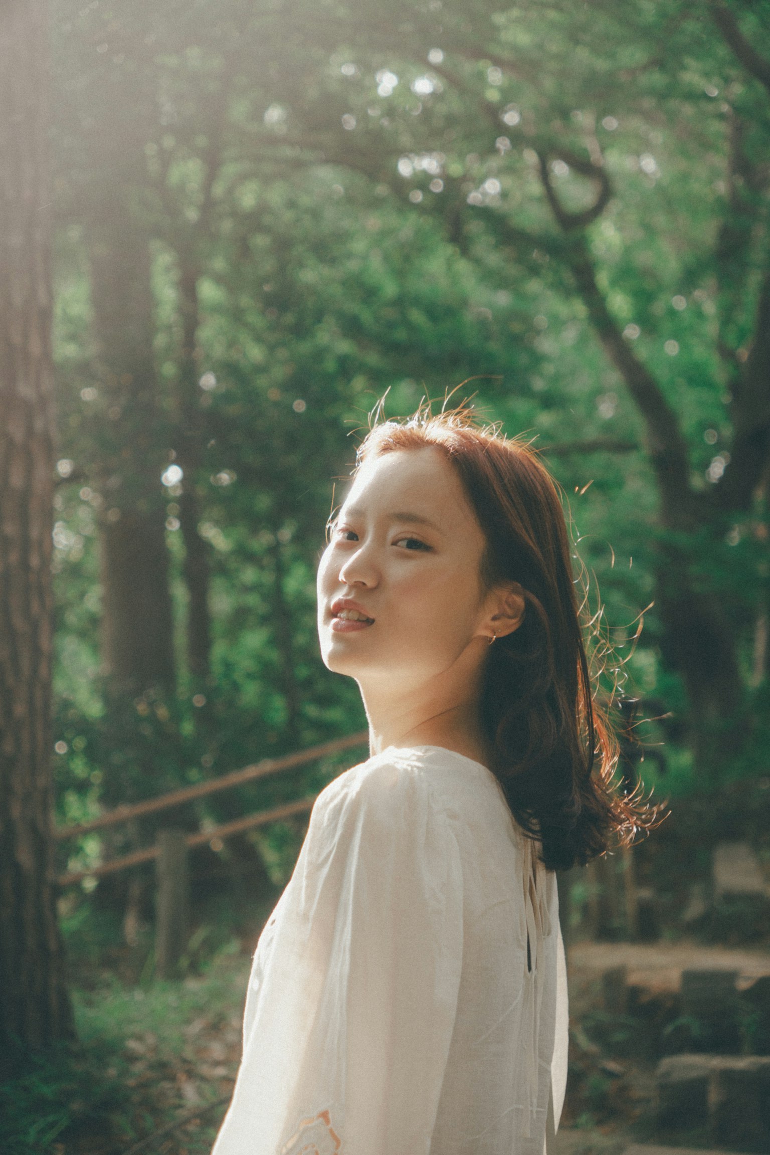 站在绿色背景前的女性肖像，柔和的光线照耀
