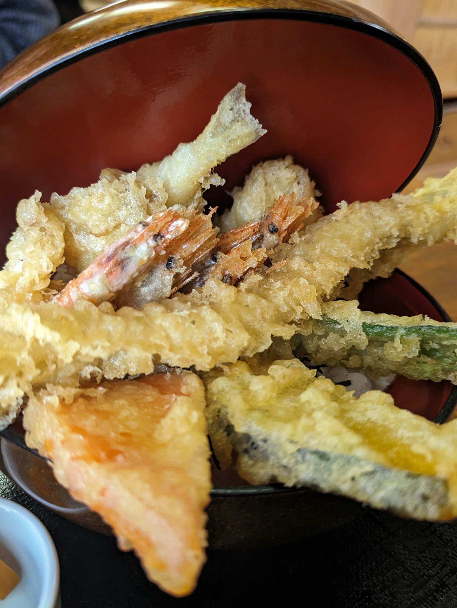 Un piatto di tempura assortita in una ciotola rossa
