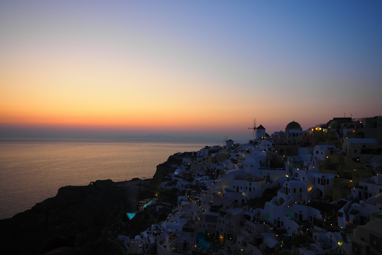 Cảnh hoàng hôn ở Santorini với các tòa nhà trắng và đại dương
