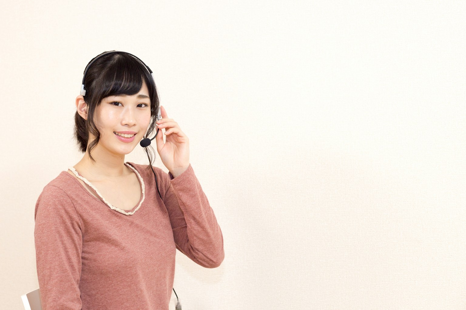 A smiling woman wearing a headset