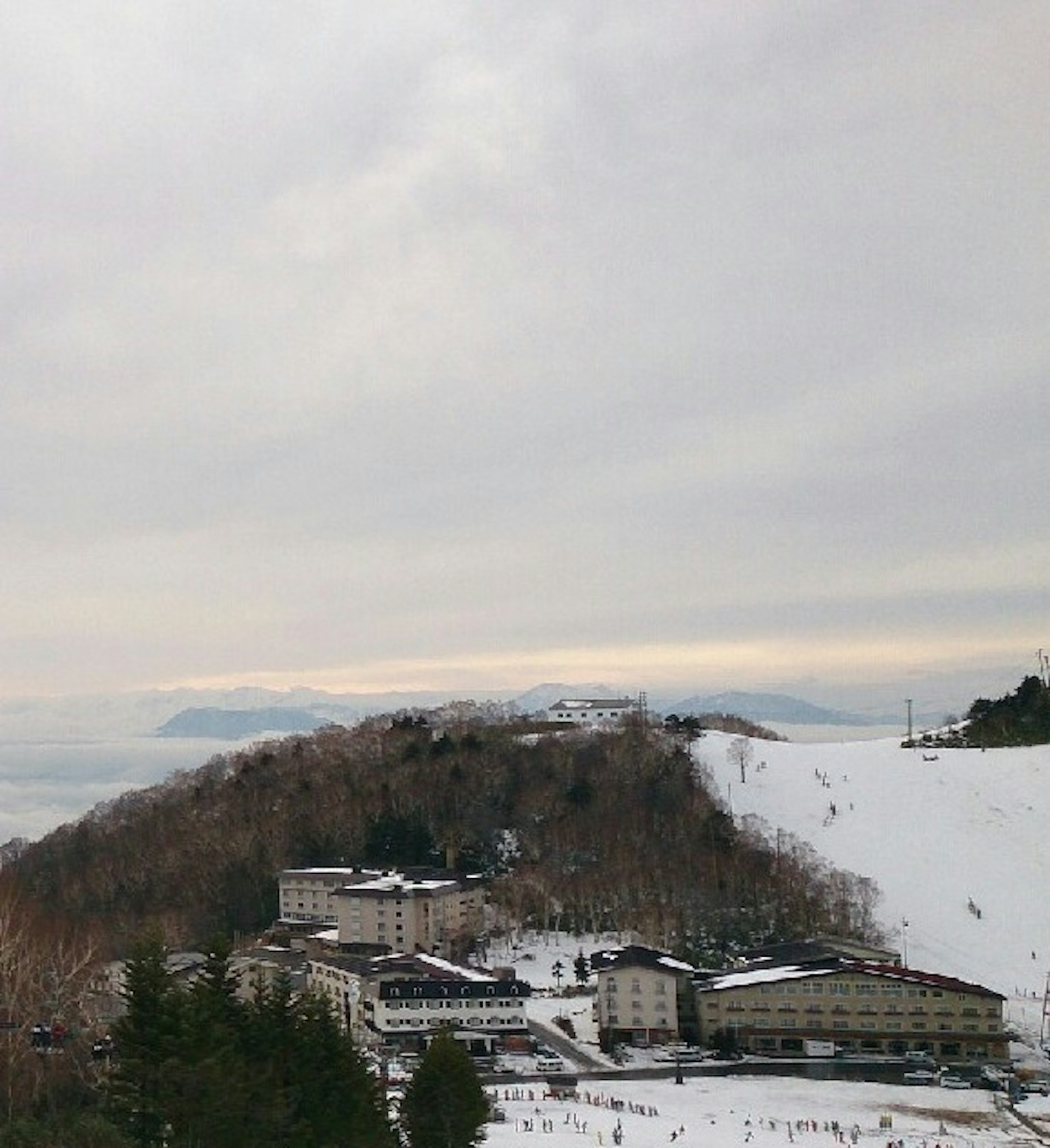 눈 덮인 산비탈에 있는 숙소와 먼 산들