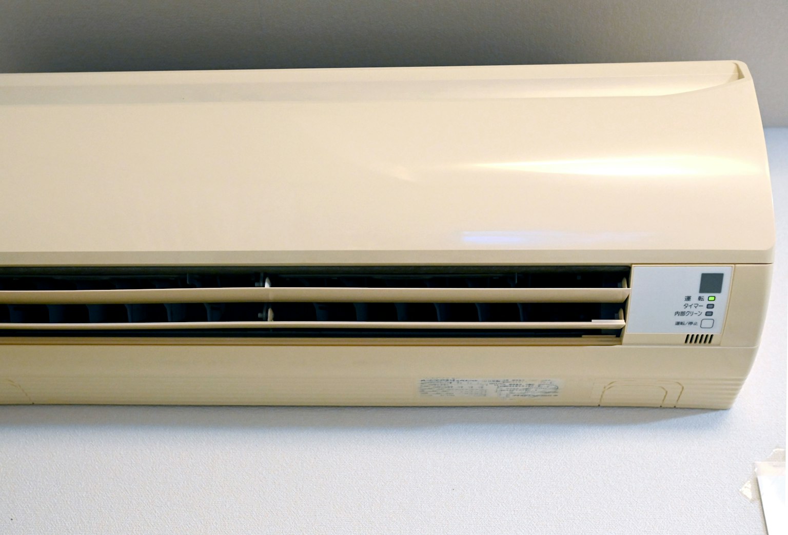 Air conditioner with a white exterior and slit ventilation openings