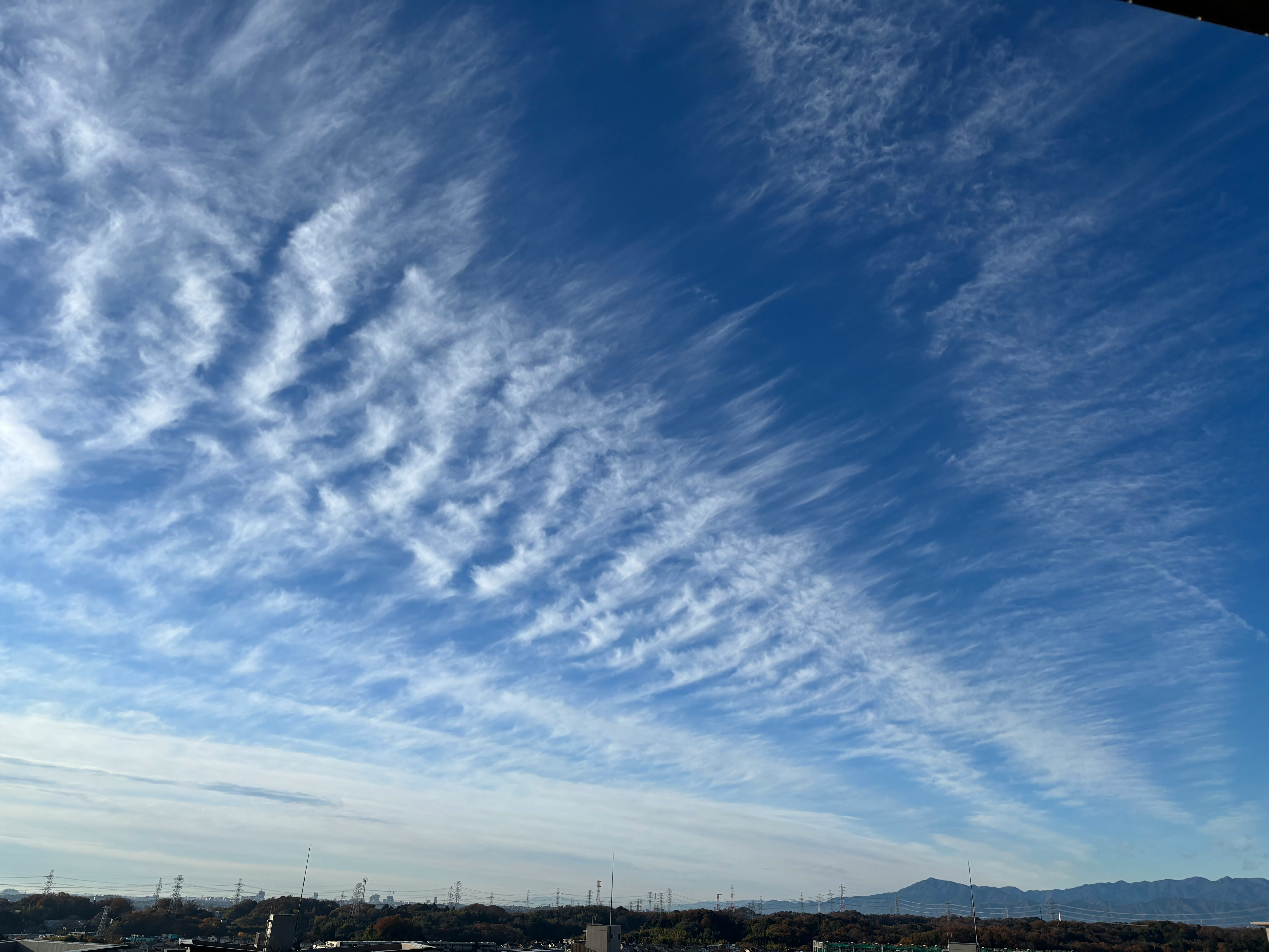 雲が広がる青空と遠くの山並み