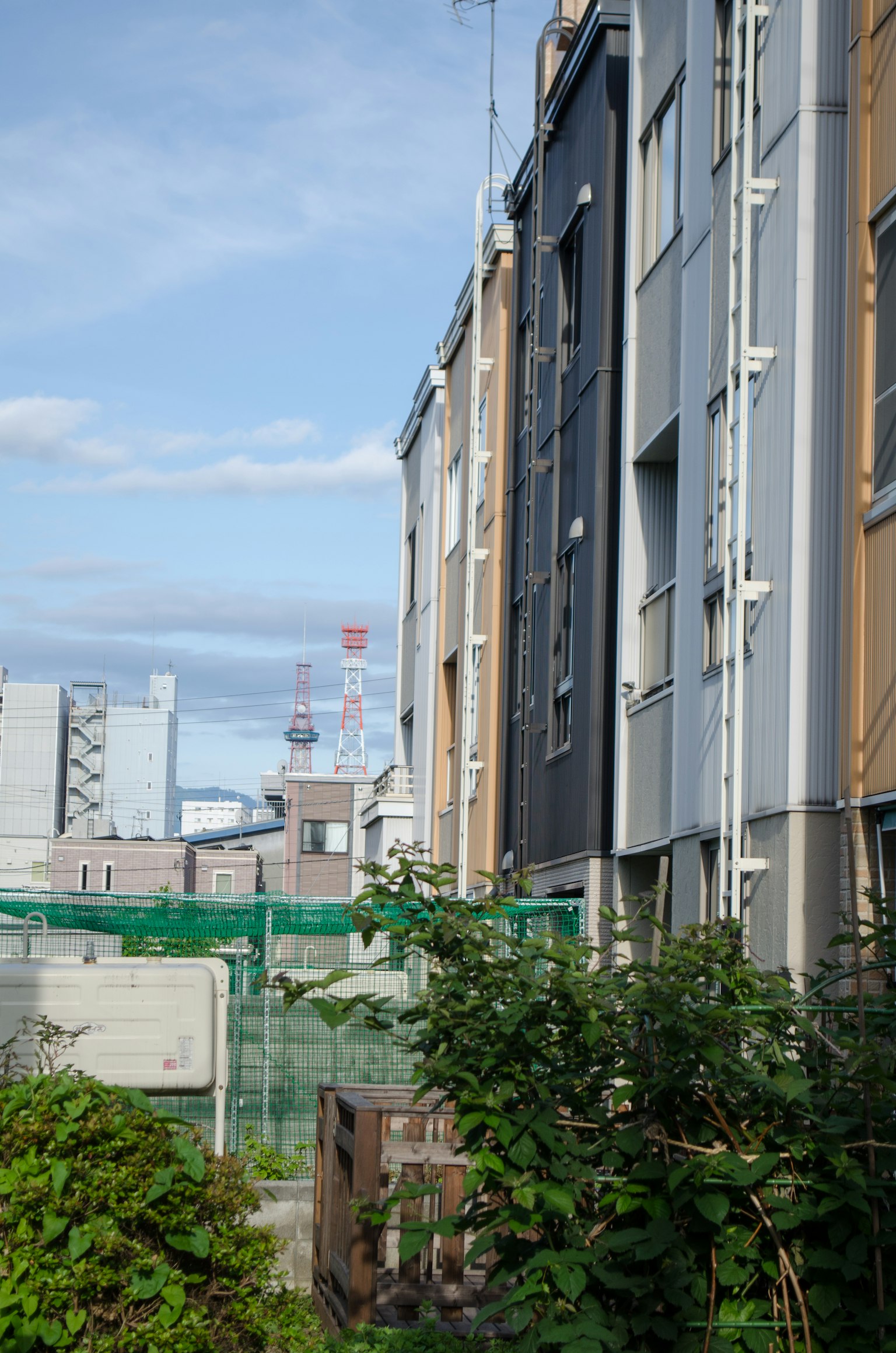 Vista delle facciate degli edifici con vegetazione in primo piano
