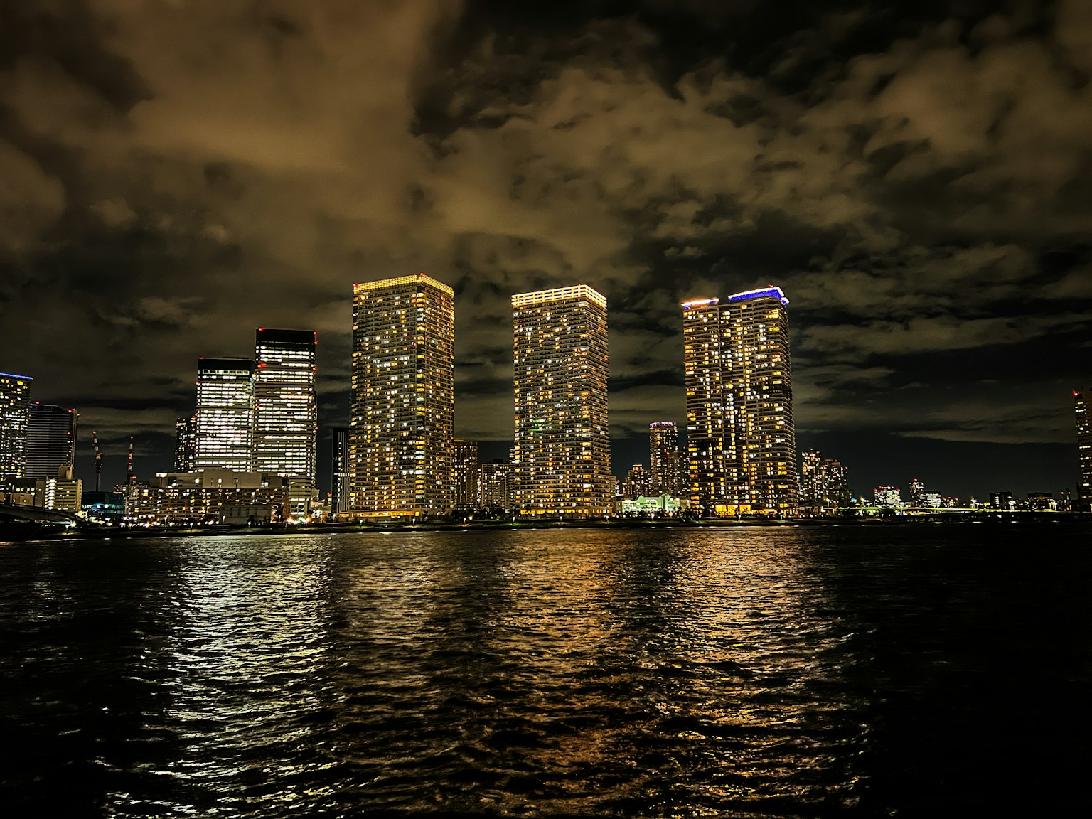 Vista nocturna de rascacielos reflejándose en el agua