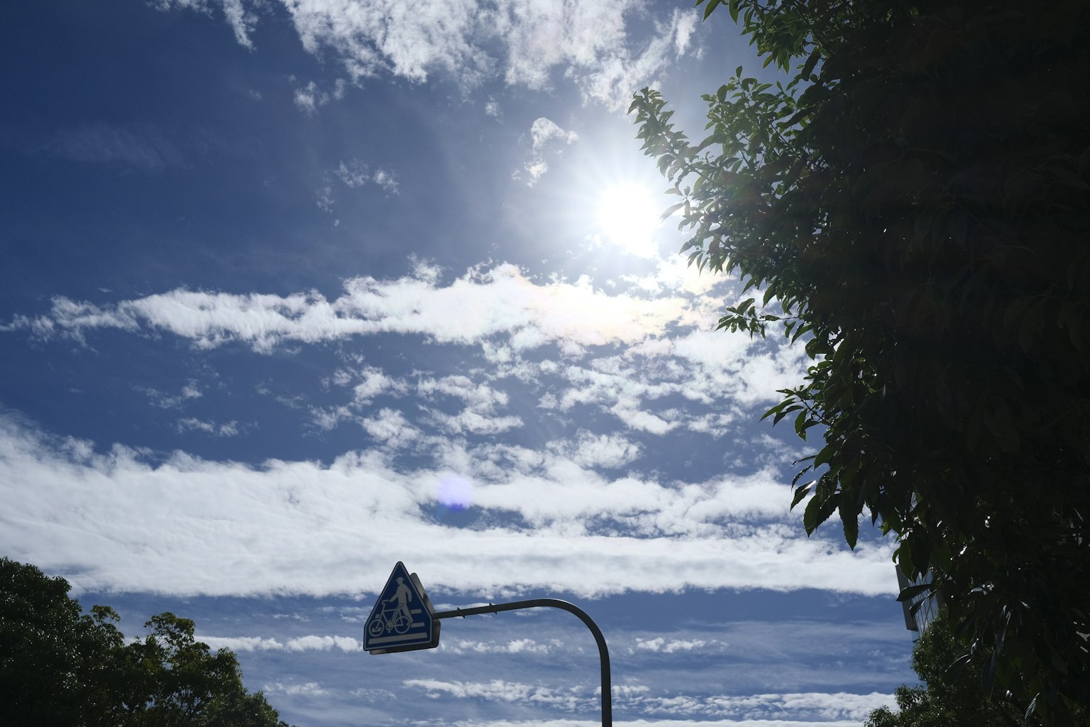 Una farola bajo un cielo azul con nubes dispersas