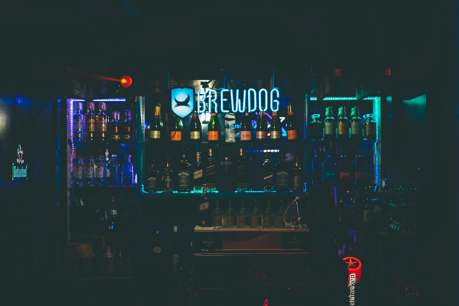 Intérieur d'un bar BrewDog avec un éclairage coloré et une variété de bouteilles