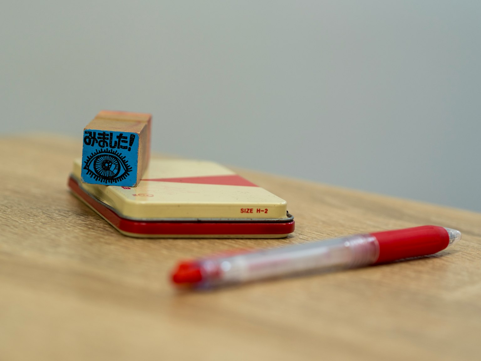Roter Stift und Stempel auf einem Notizbuch auf einem Holztisch