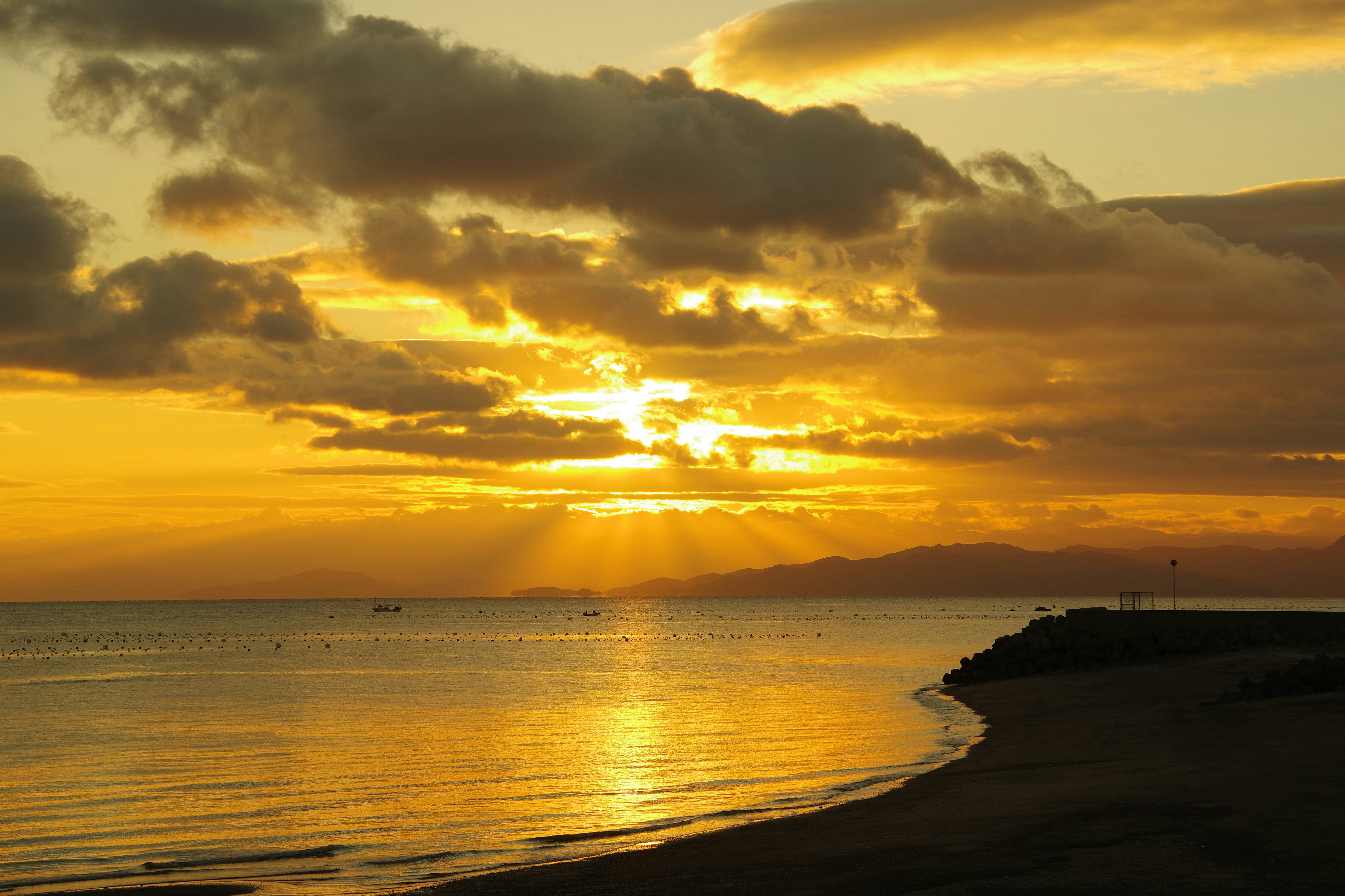 Paysage côtier au lever du jour avec des rayons crépusculaires sur la mer d’Ariake