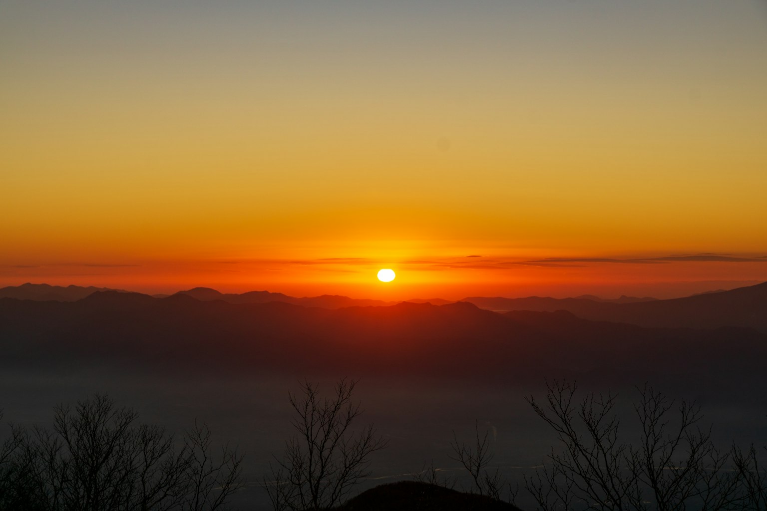 Sonnenuntergang über den Bergen mit lebhaften Orange- und Gelbtönen