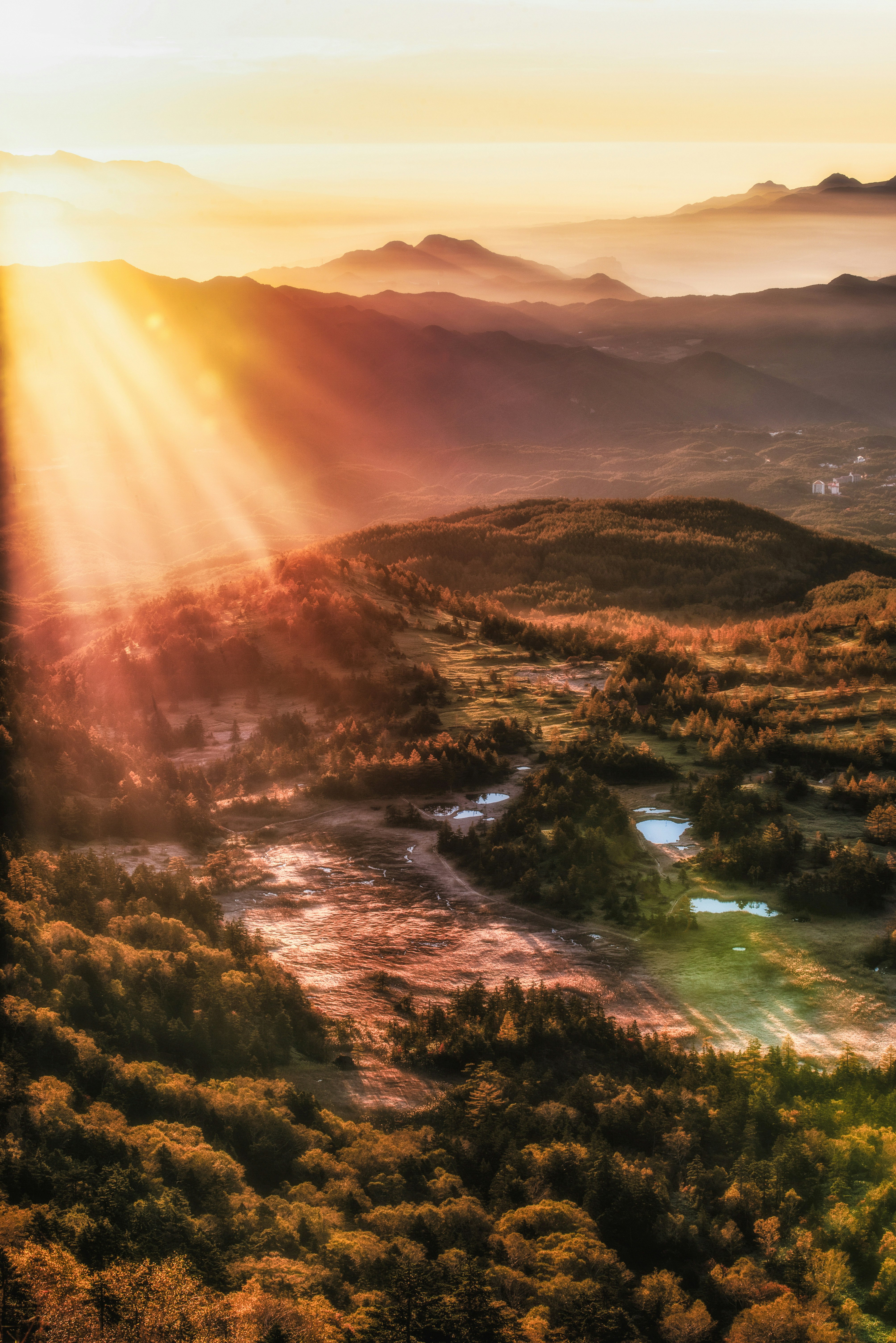 Sonnenaufgang über Bergkämmen und einem nebligen Tal