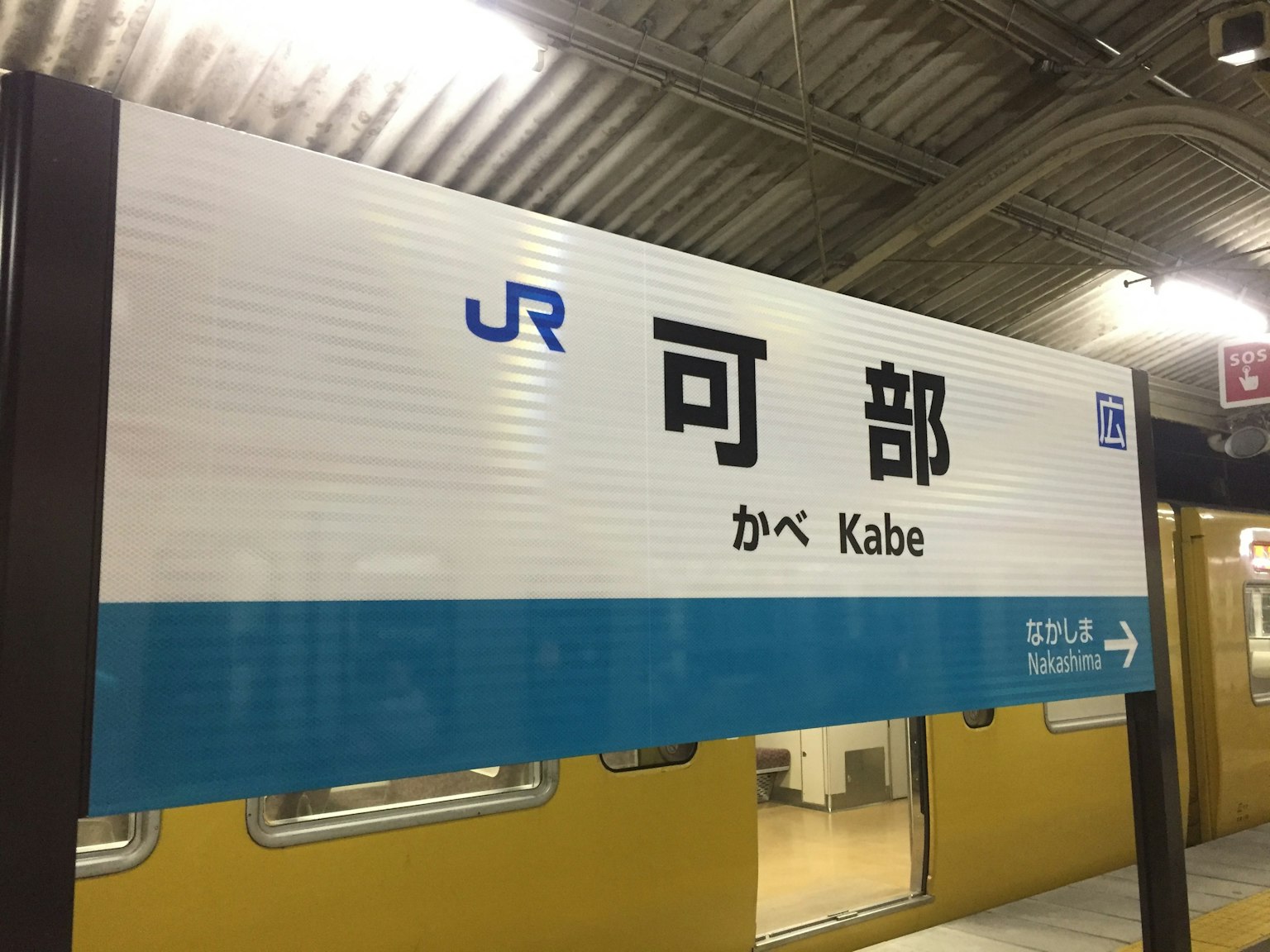 Panneau de la station JR Kabe avec des caractères japonais et une bande bleue