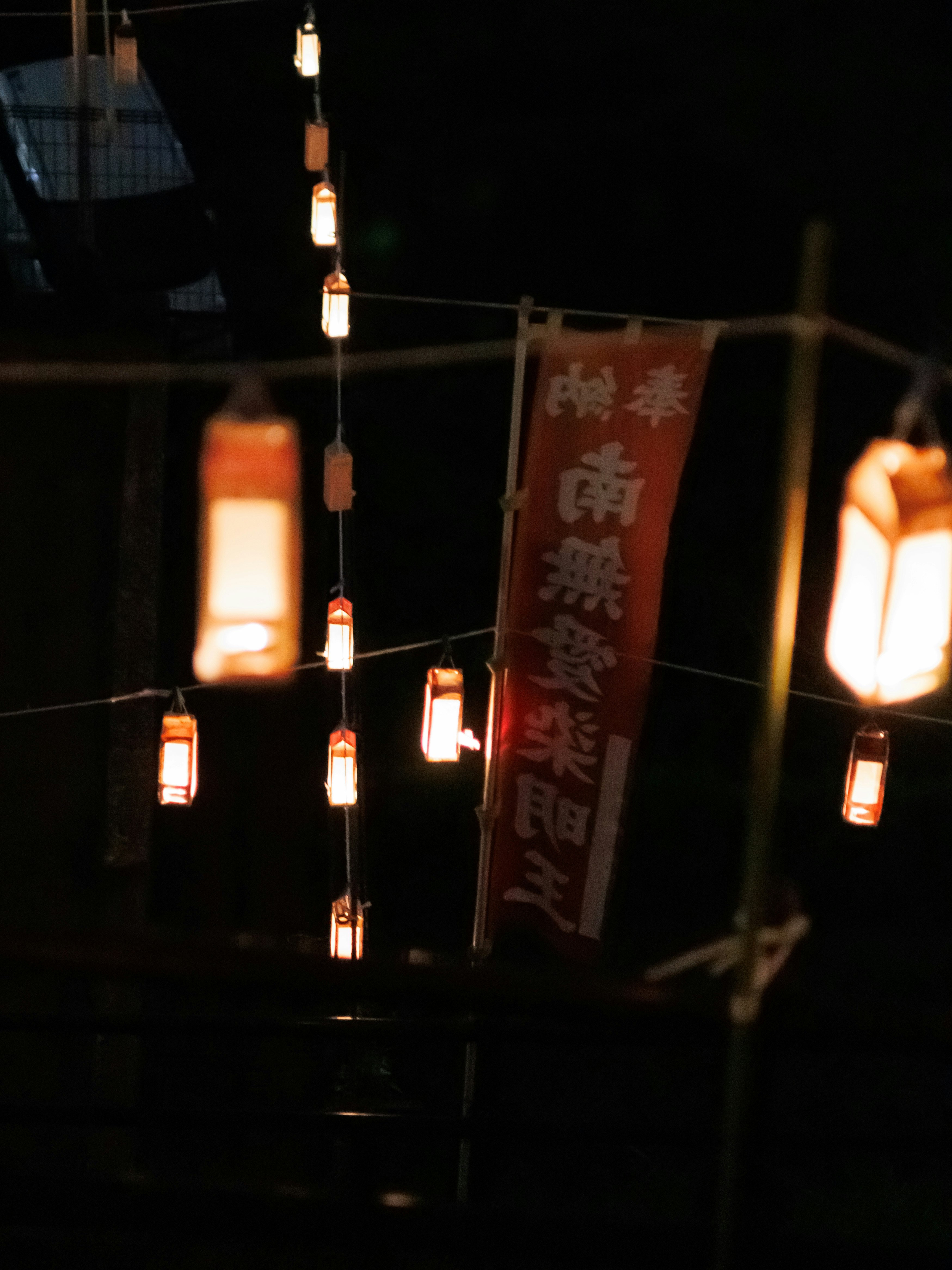 送り火萬灯会の提灯が揺れる夜の路地