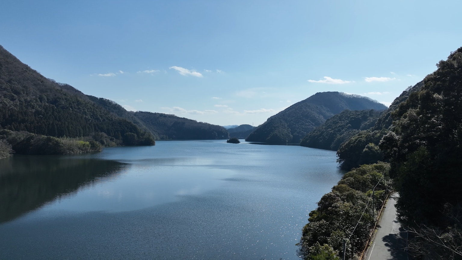 Vista serena del lago rodeado de montañas cielo azul claro reflejado en el agua