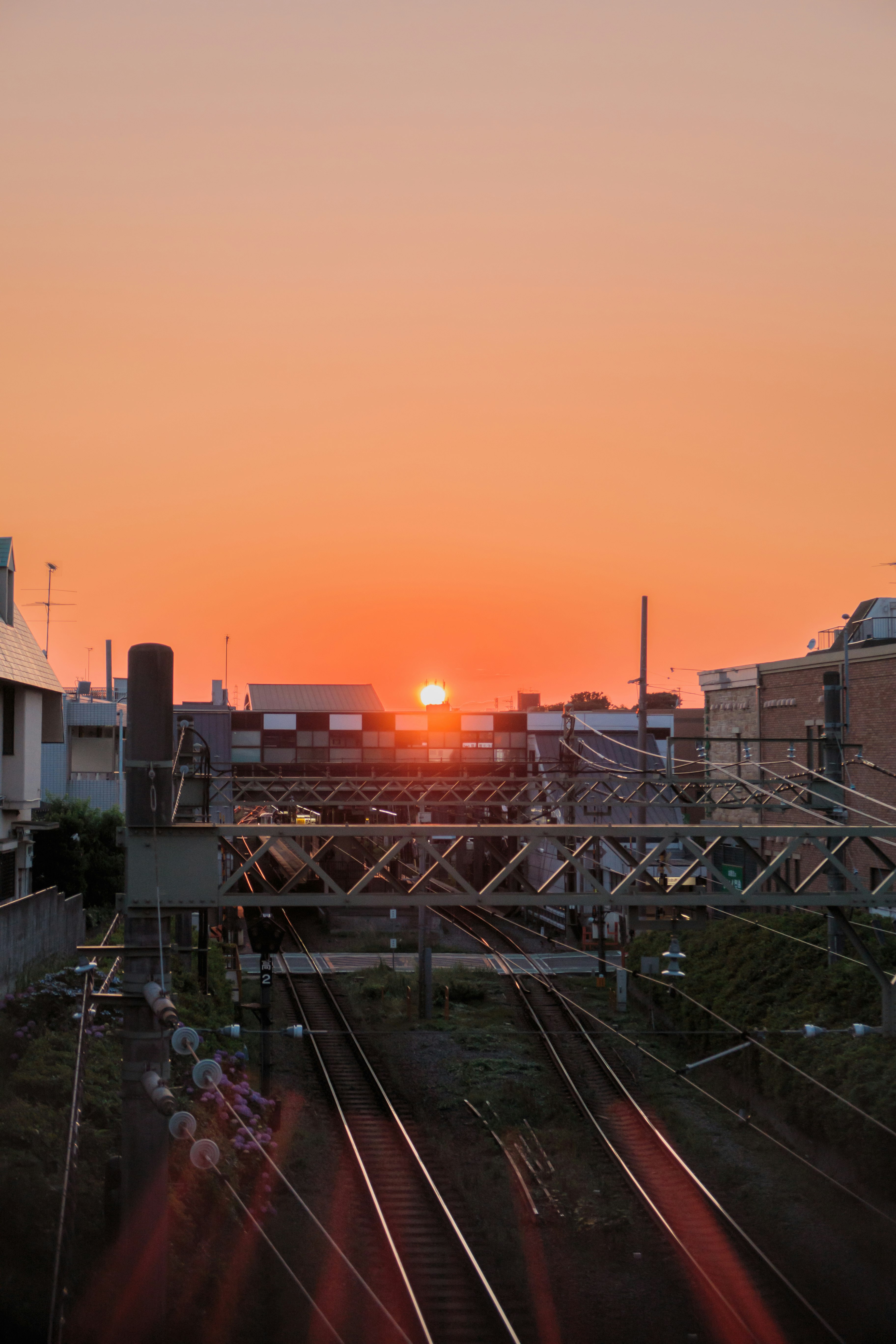 Sunset over railway tracks with urban background